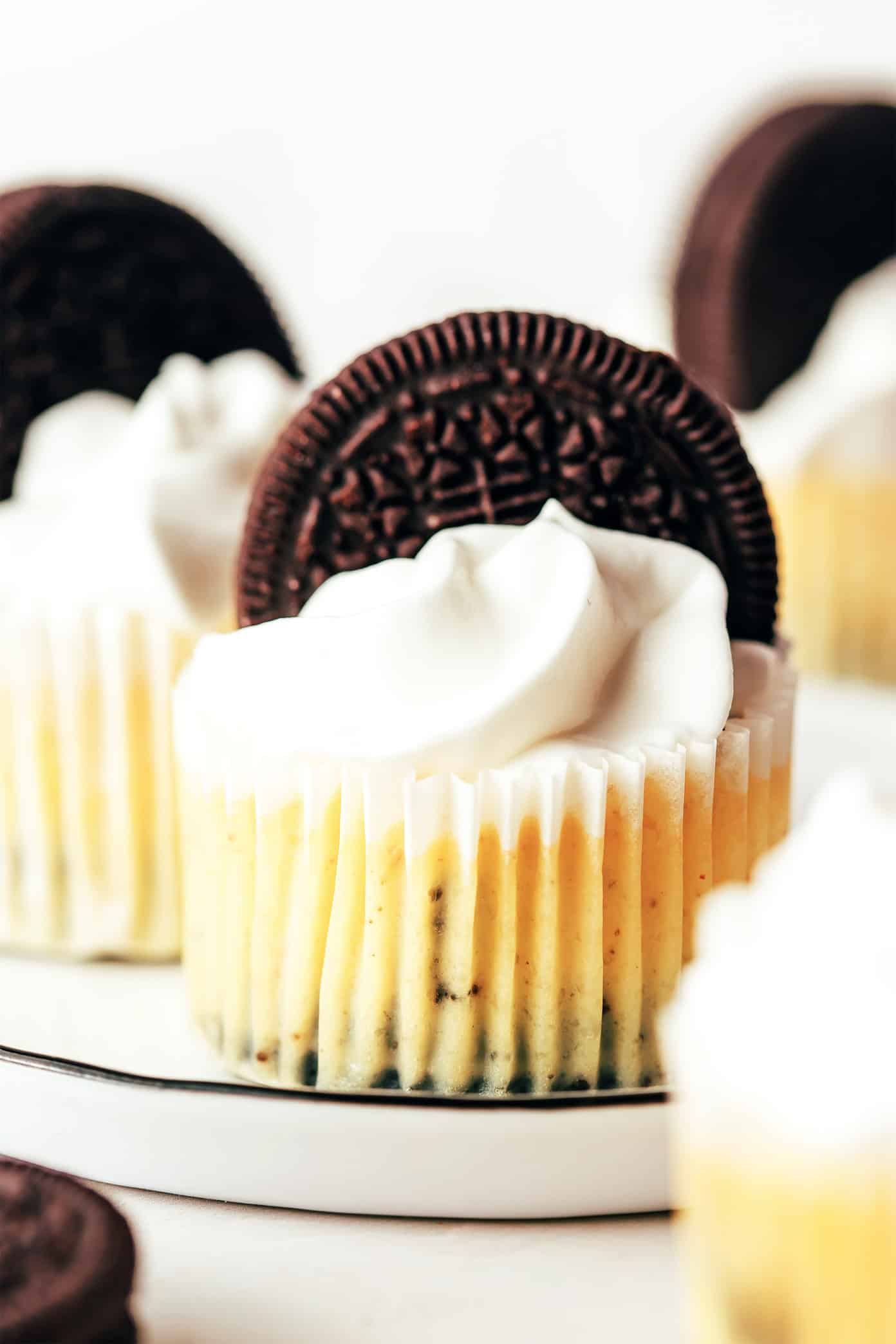 These mini Oreo cheesecakes are easy to make with a delicious mix of cookies and cream, featuring a whole chocolate Oreo as the "crust." Such a fun, simple, and delicious make-ahead dessert! | gimmesomeoven.com Mini Oreo Cheesecakes Closeup