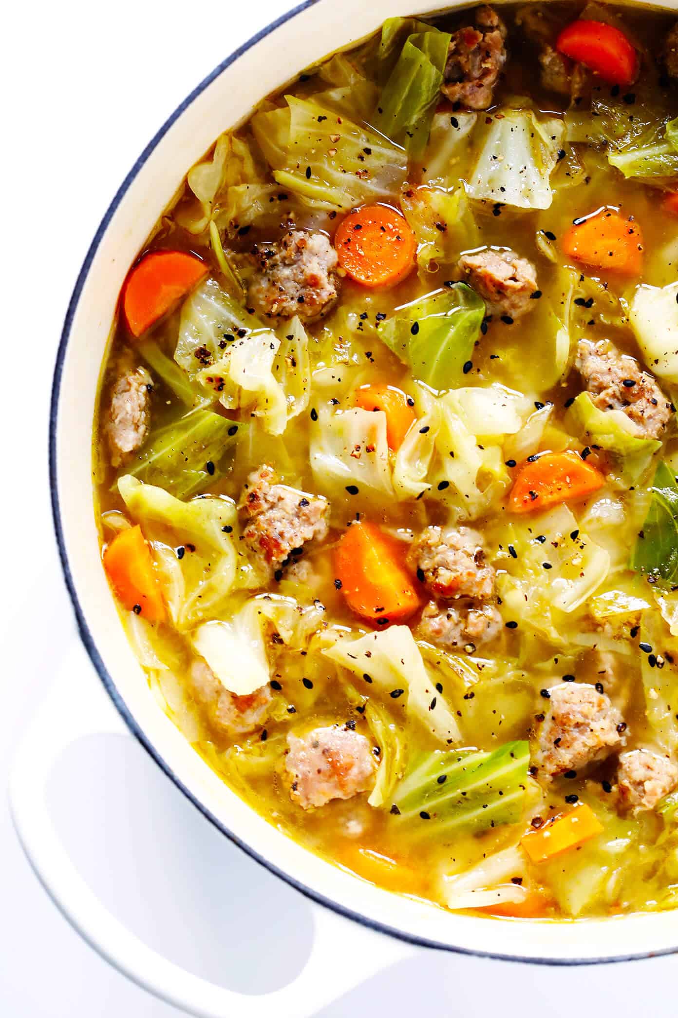 This Egg Roll Soup recipe is SO tasty!! It's basically an Asian cabbage soup, simmered with zesty sausage, carrots, sesame and ginger, and topped with crispy wonton strips if desired. It's the perfect easy dinner recipe. | Gimme Some Oven #glutenfree #soup #recipe #gf