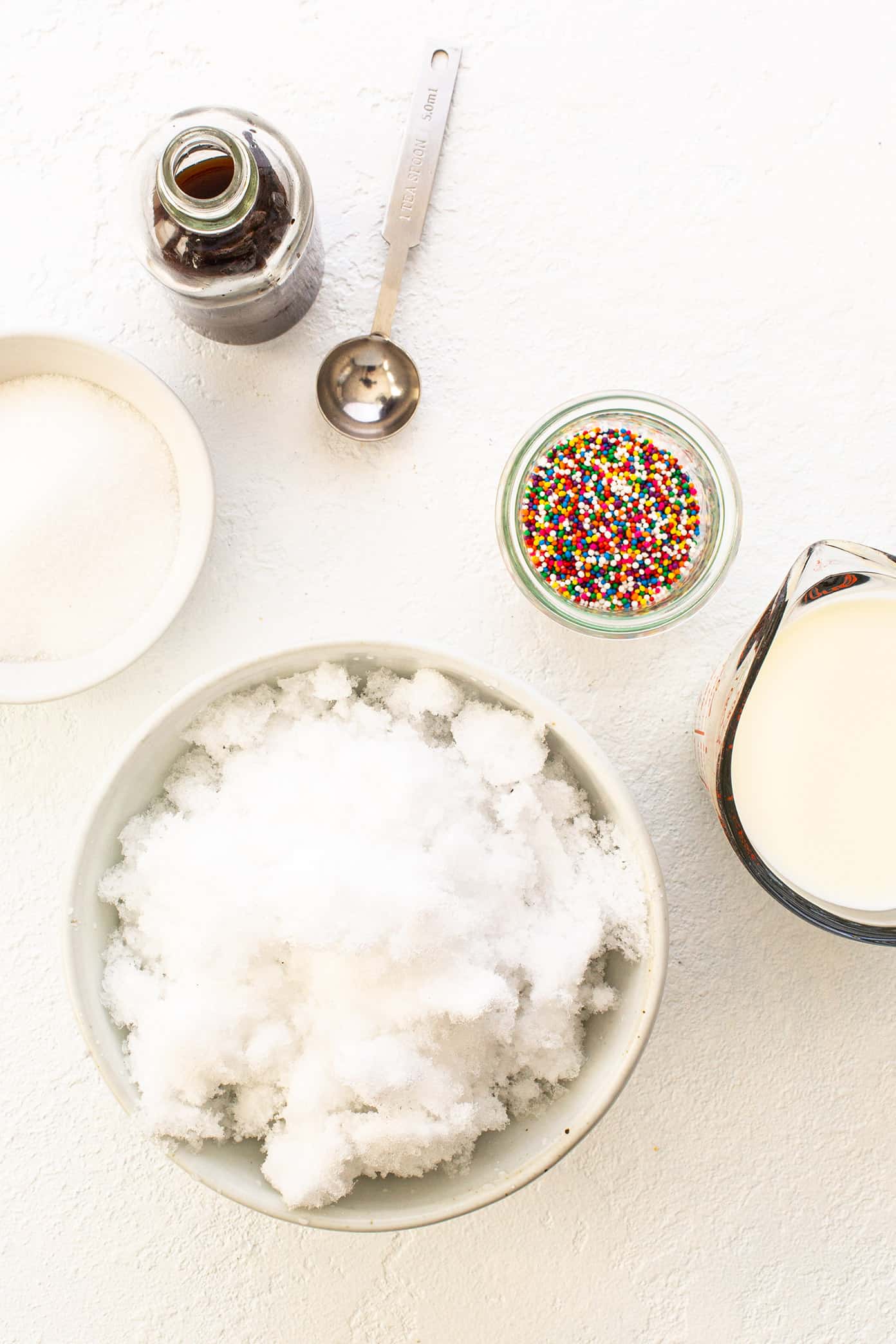 This fun snow ice cream recipe is super fun and easy to make in just 5 minutes! All you need are a few scoops of fresh snow (or shaved ice), milk, sugar, vanilla and a pinch of salt. It's the perfect snow day activity for kids...or kids at heart! | gimmesomeoven.com Snow Ice Cream Ingredients