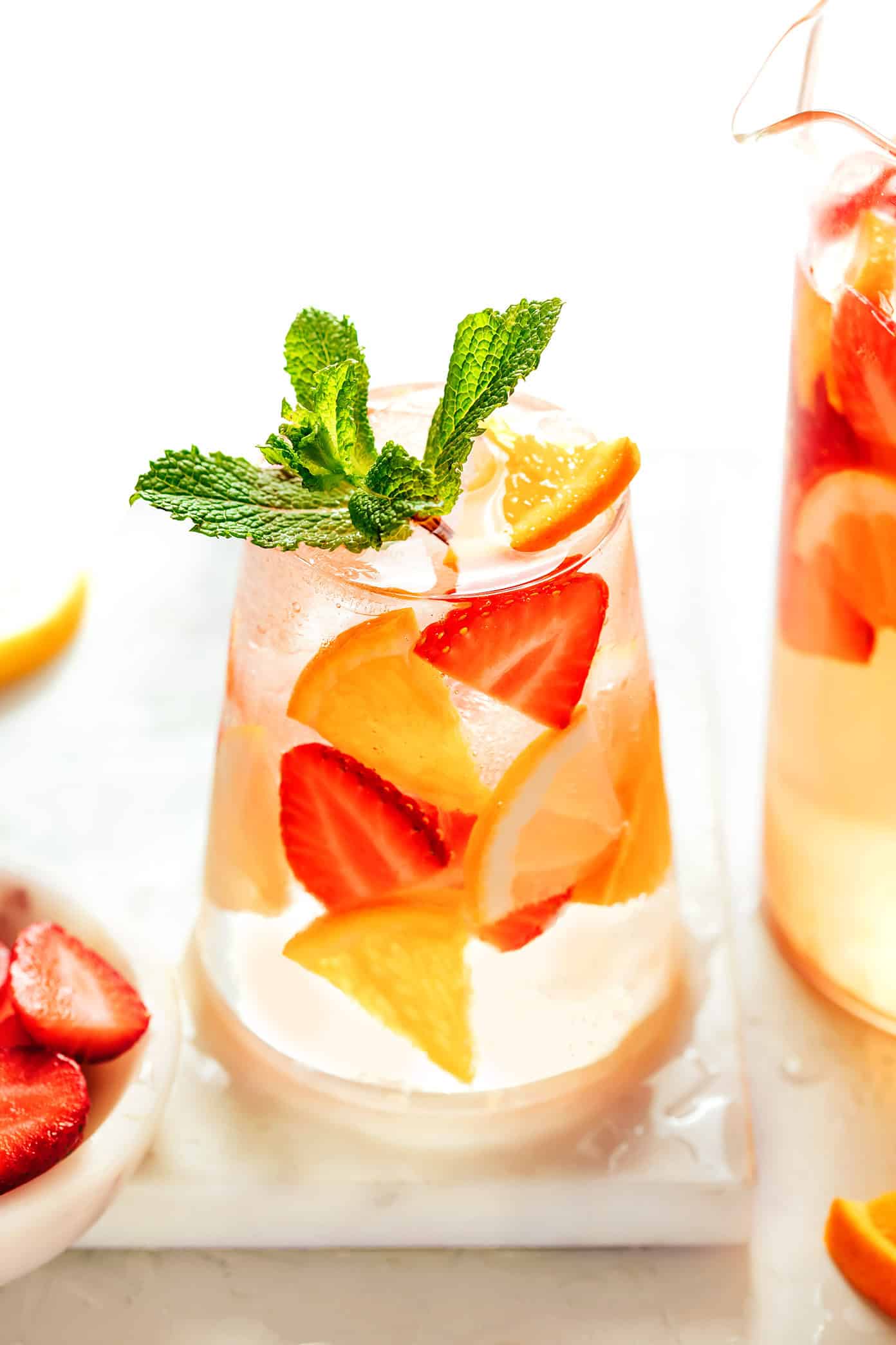 This easy strawberry sangria recipe is made with fresh strawberries, citrus, white wine, and orange liqueur for a refreshing and fruity summer drink. | gimmesomeoven.com strawberry sangria glass and pitcher