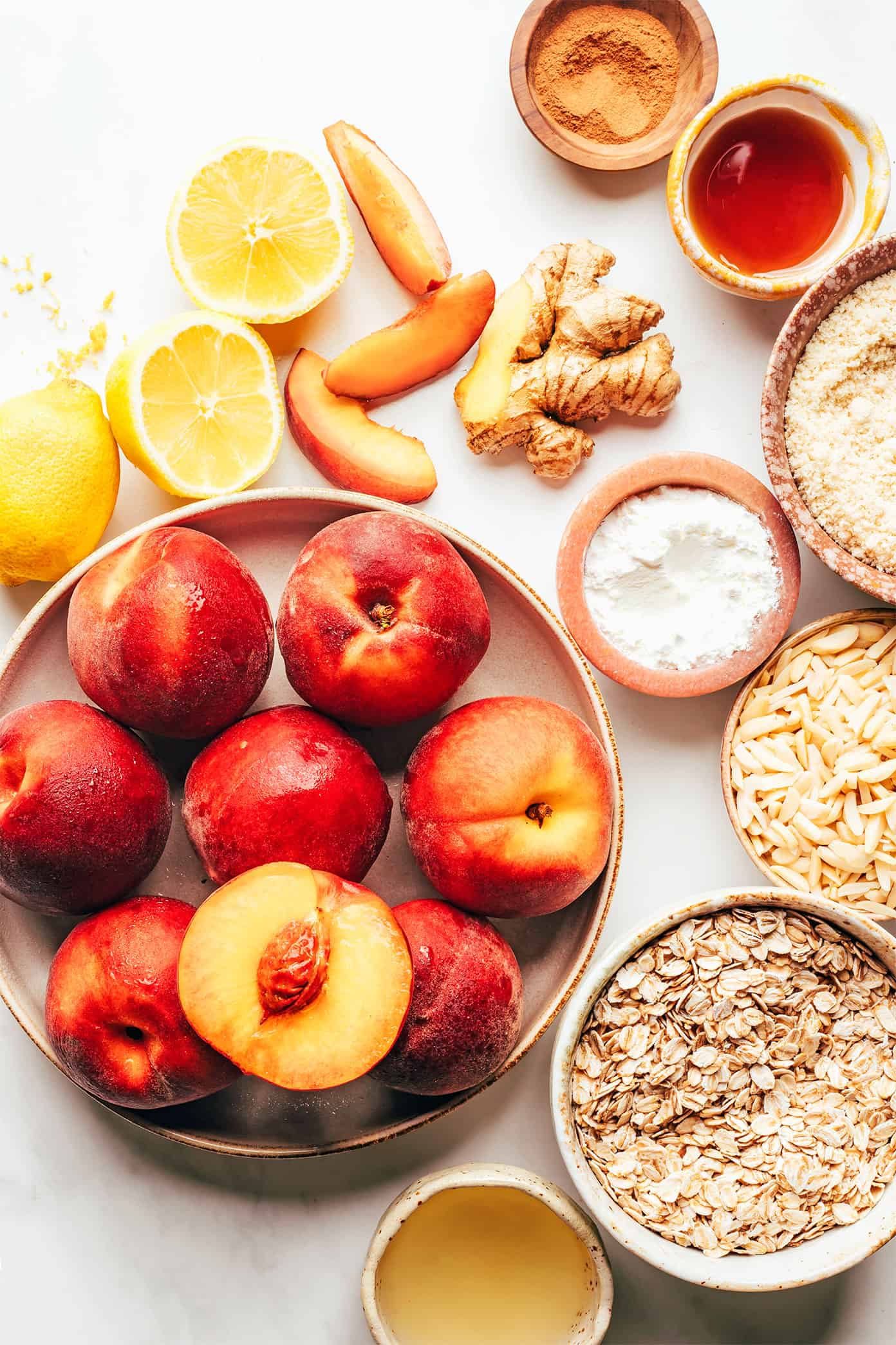This ginger peach crisp recipe is made with a warm ginger-vanilla peach filling and topped with a crispy almond oat topping. Easy to make, naturally gluten-free and vegan, and SUCH a delicious summer dessert! | gimmesomeoven.com Peach Crisp Ingredients