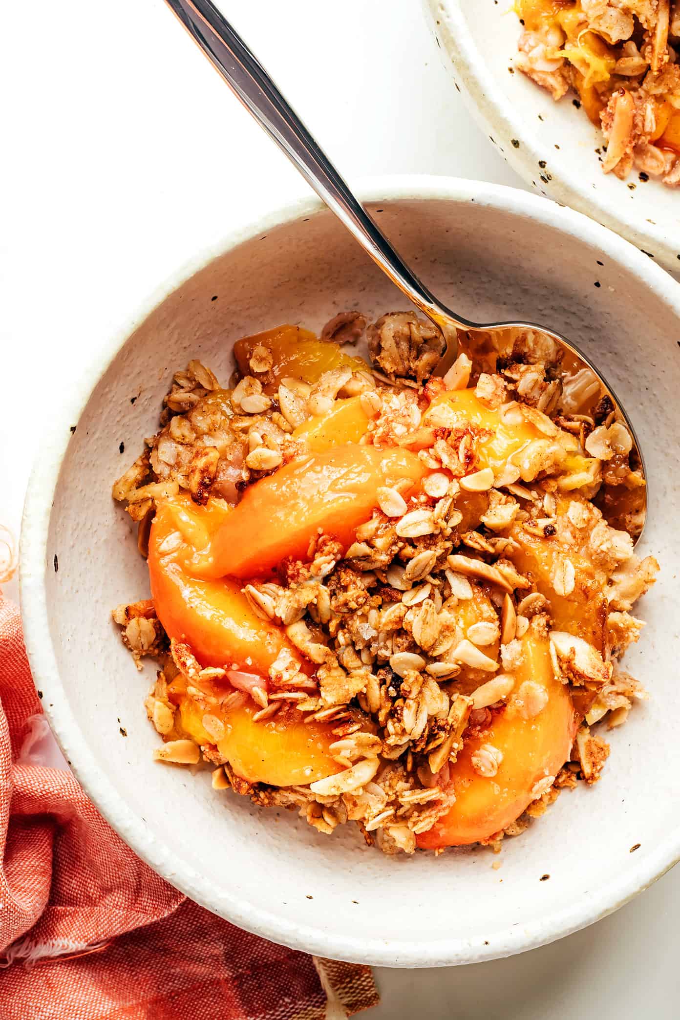 This ginger peach crisp recipe is made with a warm ginger-vanilla peach filling and topped with a crispy almond oat topping. Easy to make, naturally gluten-free and vegan, and SUCH a delicious summer dessert! | gimmesomeoven.com Ginger Peach Crisp