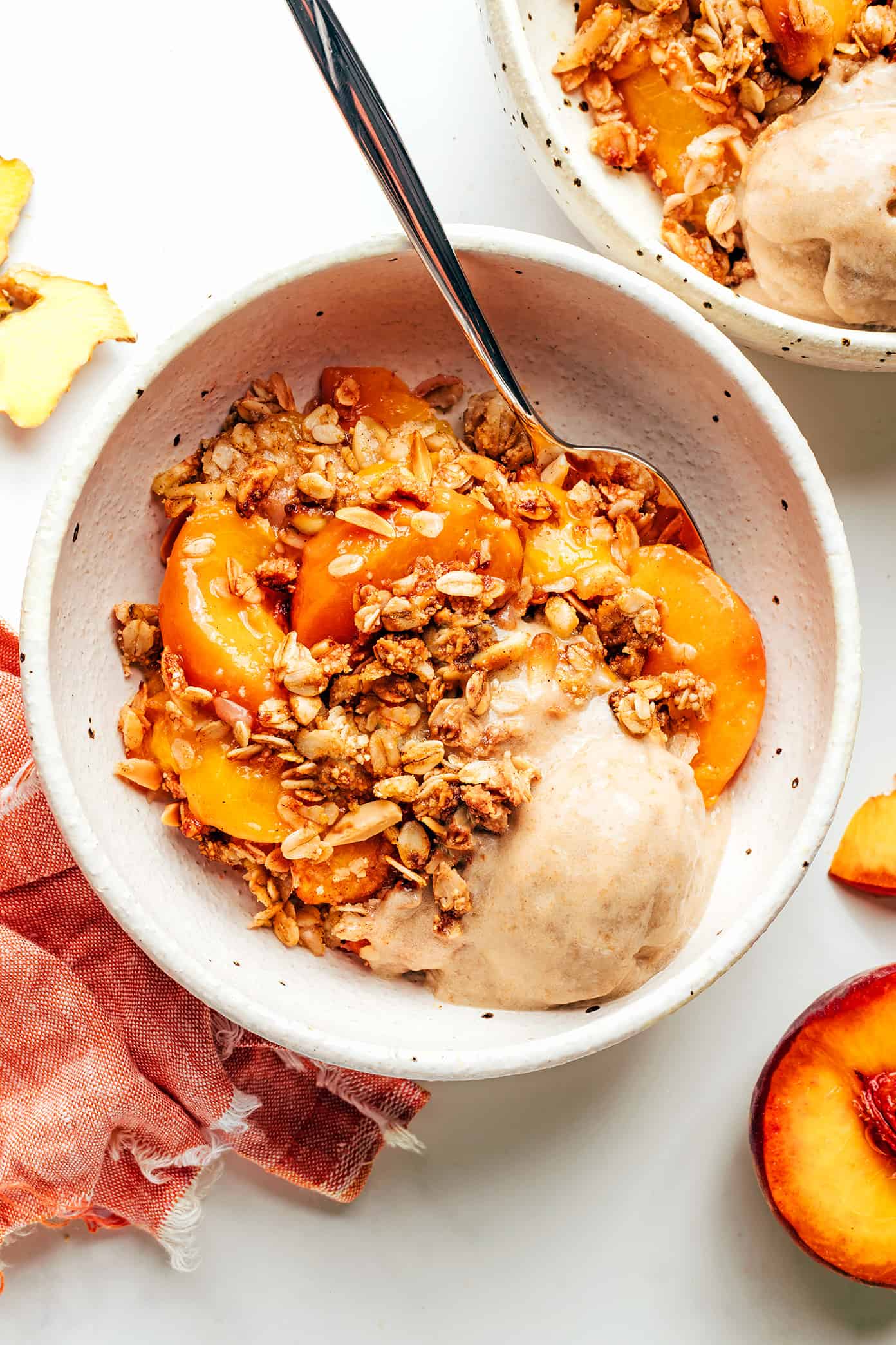 This ginger peach crisp recipe is made with a warm ginger-vanilla peach filling and topped with a crispy almond oat topping. Easy to make, naturally gluten-free and vegan, and SUCH a delicious summer dessert! | gimmesomeoven.com Ginger Peach Crisp with Ice Cream