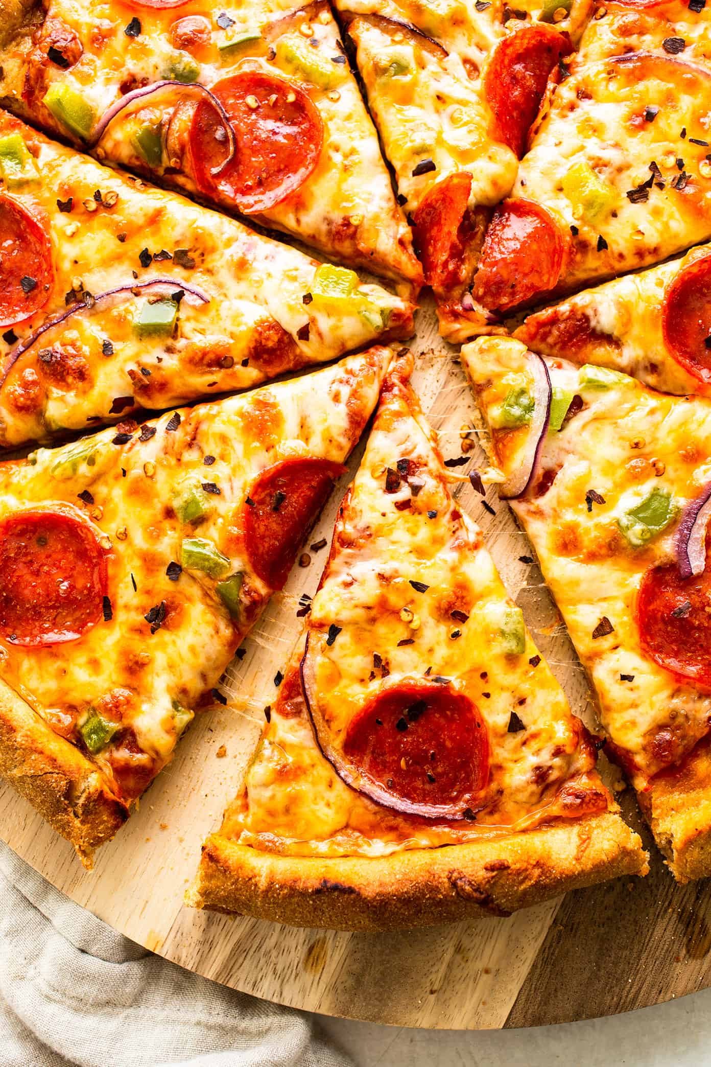 My favorite homemade whole wheat pizza dough recipe is easy to make by hand or with a stand mixer, it's naturally sweetened with a hint of honey, and it's always perfectly chewy and delicious. Feel free to add Italian seasoning, garlic, or Parmesan to your pizza crust too if you'd like! | gimmesomeoven.com Homemade pizza with whole wheat pizza dough