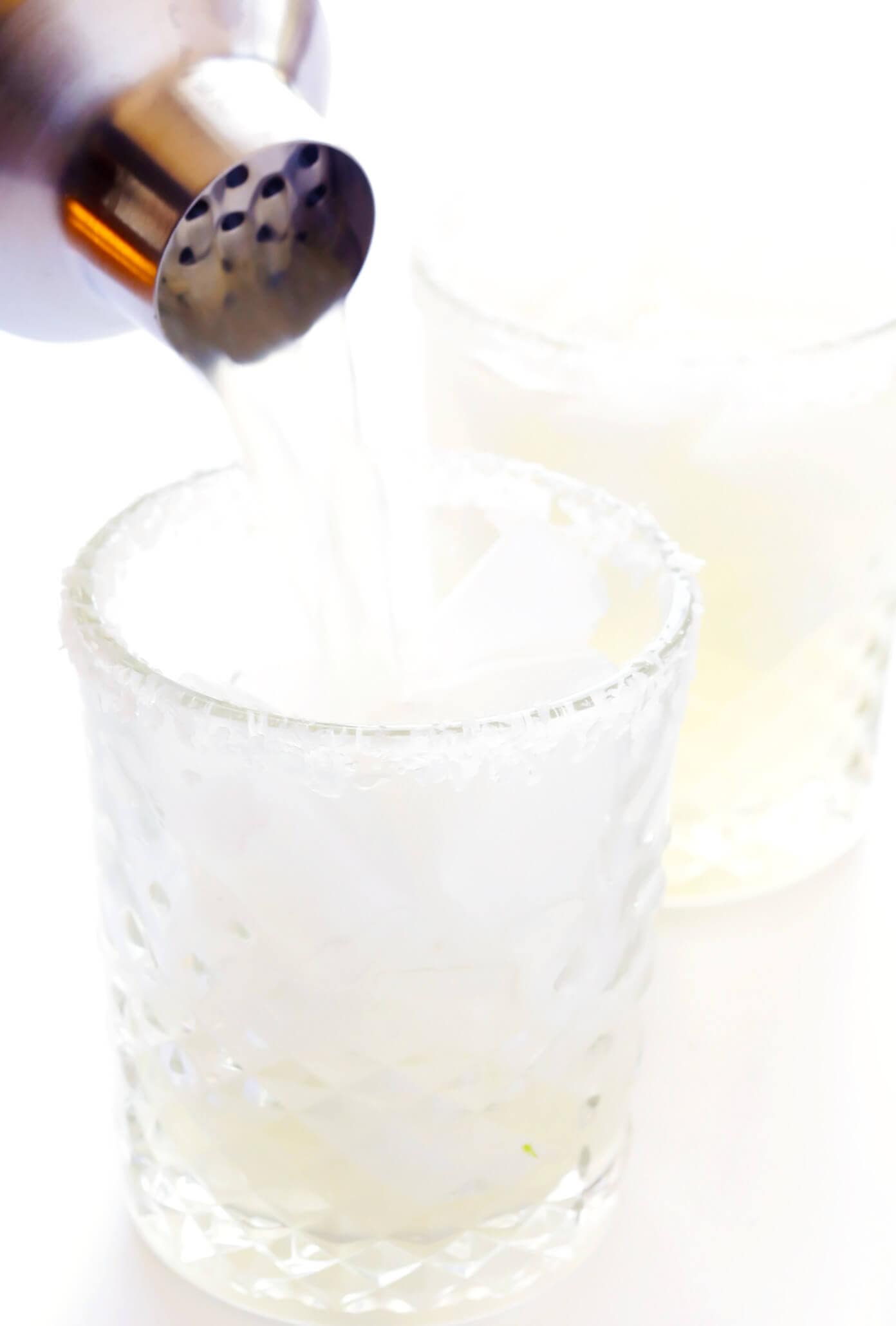 Learn how to make a margarita with this classic 3-ingredient margarita recipe! Instructions included for how to make a single-serving margarita cocktail or pitcher margaritas for a crowd. Plus options to make your drink smoky (with mezcal in place of tequila), spicy (with jalapeños or Tajín) or "skinny" (with fresh orange juice). | gimmesomeoven.com How To Make Margaritas with a Cocktail Strainer