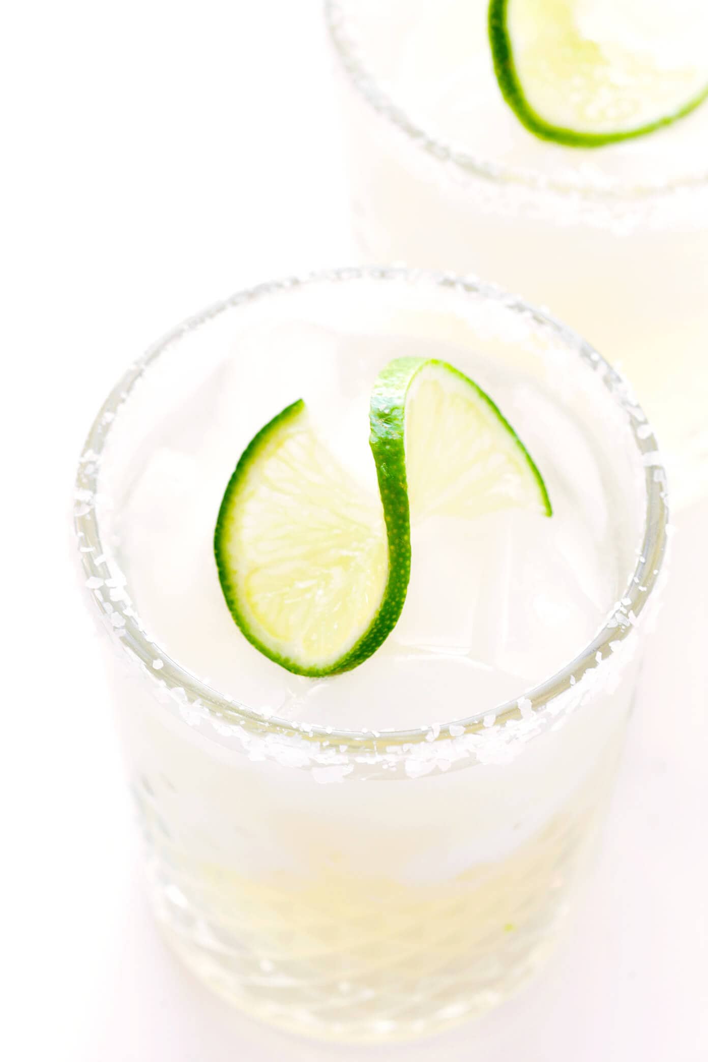 Learn how to make a margarita with this classic 3-ingredient margarita recipe! Instructions included for how to make a single-serving margarita cocktail or pitcher margaritas for a crowd. Plus options to make your drink smoky (with mezcal in place of tequila), spicy (with jalapeños or Tajín) or "skinny" (with fresh orange juice). | gimmesomeoven.com Margarita Recipe in Glasses with Salt Rim
