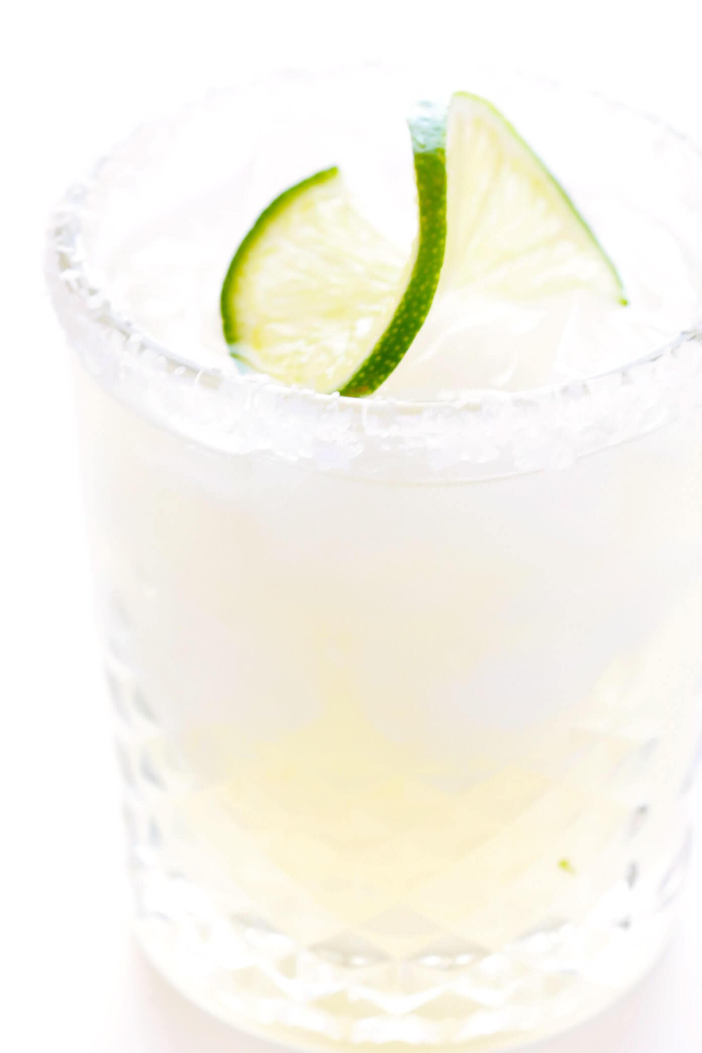 Learn how to make a margarita with this classic 3-ingredient margarita recipe! Instructions included for how to make a single-serving margarita cocktail or pitcher margaritas for a crowd. Plus options to make your drink smoky (with mezcal in place of tequila), spicy (with jalapeños or Tajín) or "skinny" (with fresh orange juice). | gimmesomeoven.com Classic Margarita Recipe in Glass with Lime