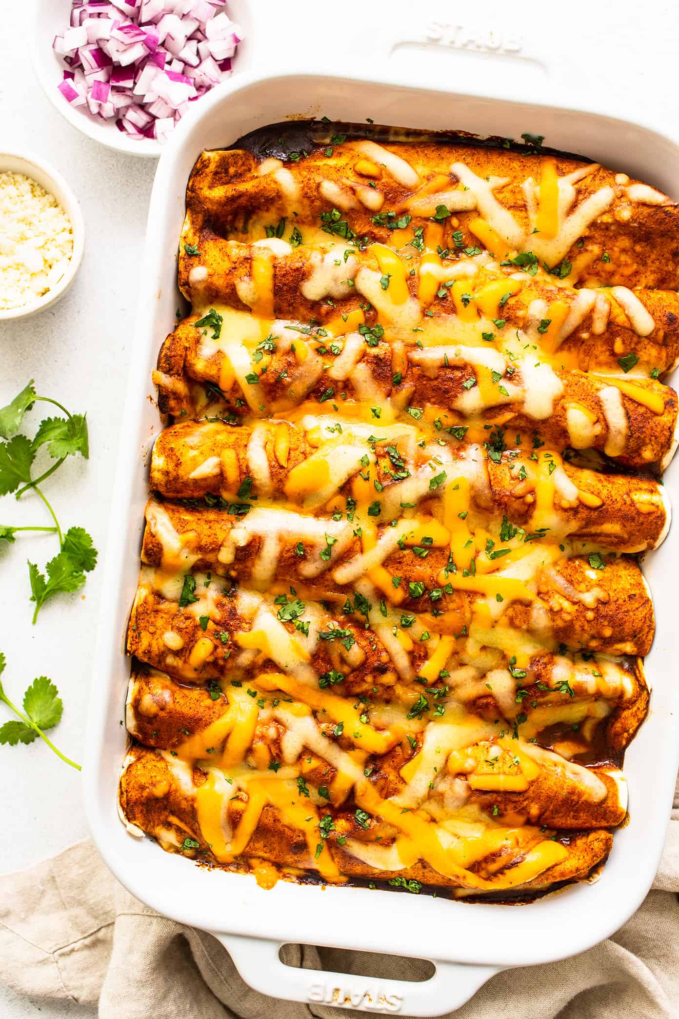 These delicious Tex-Mex-inspired enchiladas are loaded up with with tender ground beef (or plant-based meat), green chiles, onion, garlic, beans, cheese, corn or flour tortillas, and my favorite red enchilada sauce. When baked to warm and melty perfection, and served up with a few slices of avocado and perhaps a sprinkling of fresh cilantro and crumbled cotija cheese, they are always a crowd fave! Freezer and make ahead instructions included. | gimmesomeoven.com Beef Enchiladas