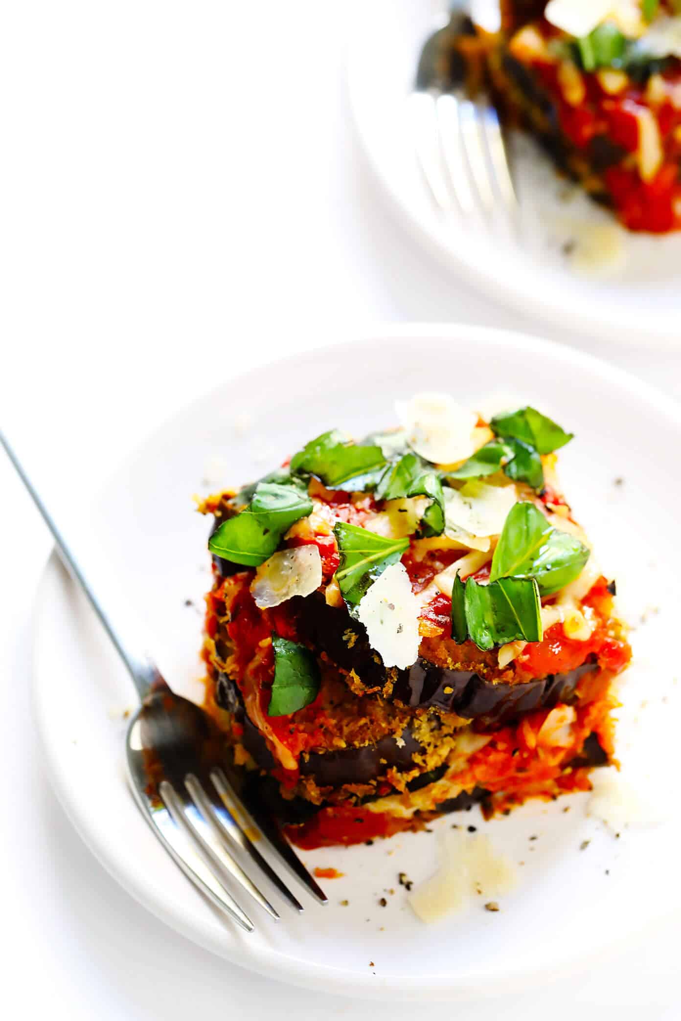 This Baked Eggplant Parmesan recipe is lightened up a bit with Panko-crusted baked (instead of fried) roasted eggplant, and layered with marinara tomato sauce, mozzarella cheese, fresh basil, and lots and lots of Parmesan. It's the perfect vegetarian casserole for Italian night, and always winner! | gimmesomeoven.com #eggplant #parmesan #vegetarian #casserole #glutenfree #italian #comfortfood #lasagna Eggplant Parmesan with Basil