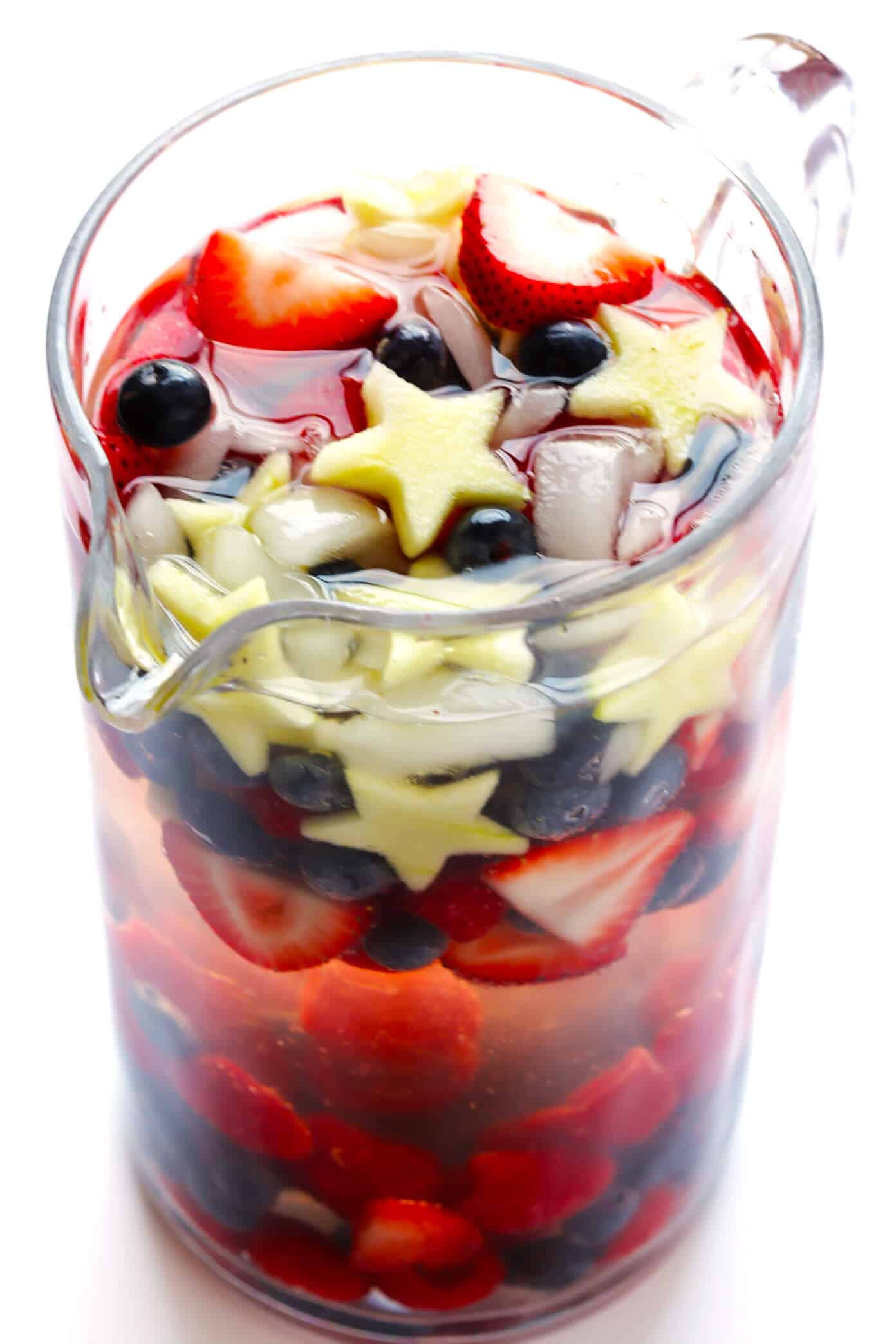 This Red, White and Blue Sparkling Sangria recipe is the perfect drink for the 4th of July or Memorial Day! It's easy to make with strawberries, blueberries, apples and your choice of wine...and always a party favorite! | gimmesomeoven.com #sangria #redwhiteandblue #cocktail #drink #4thofjuly #memorialday Red White and Blue Sparkling Sangria in a Pitcher