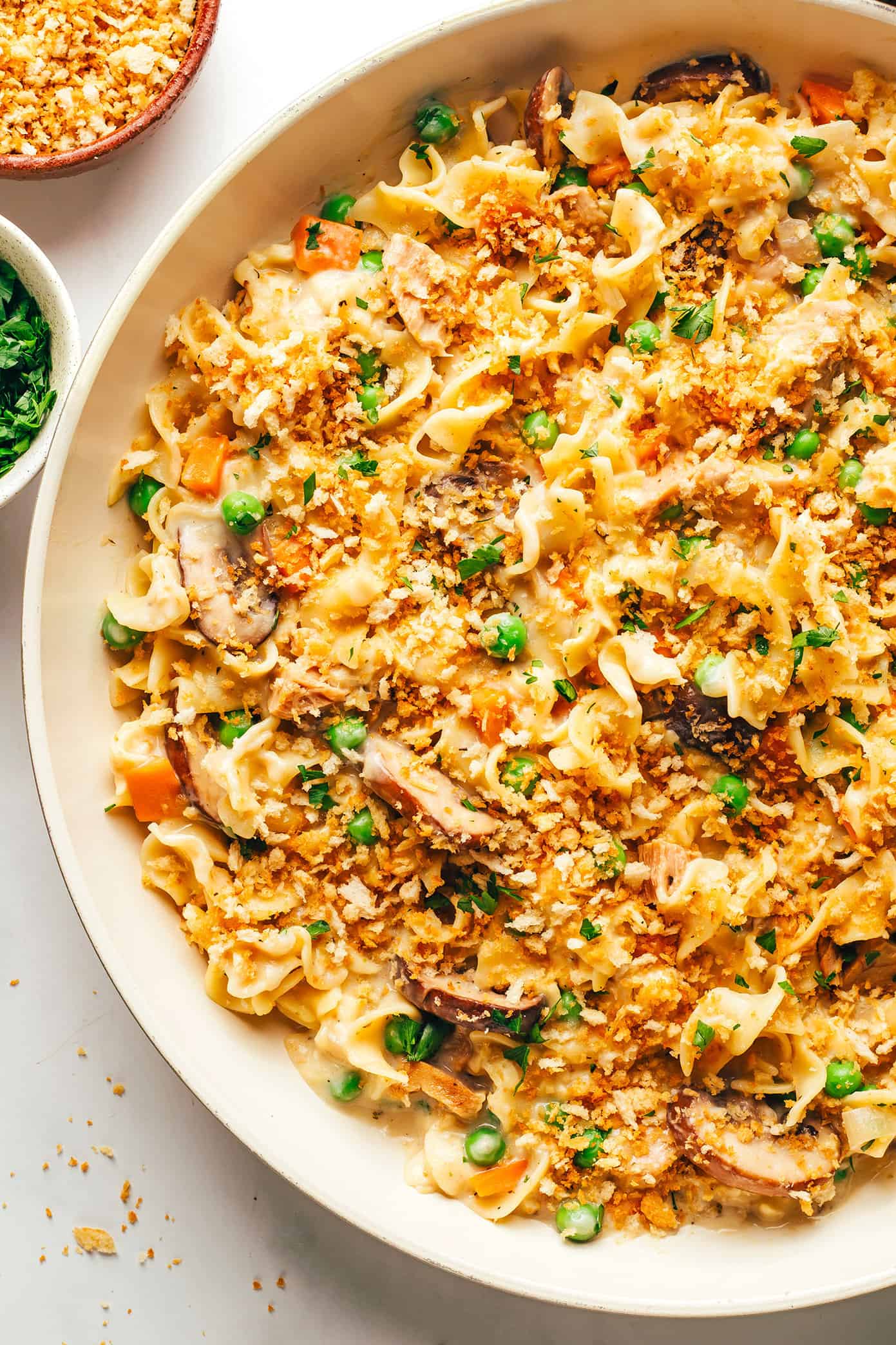 This lightened-up tuna casserole recipe is tossed with a creamy cheddar garlic-herb sauce, lots of veggies, tender egg noodles and a crispy Panko topping. A simple and delicious weeknight dinner recipe that's ready to go in just 40 minutes. | gimmesomeoven.com Tuna Noodle Casserole in Pan