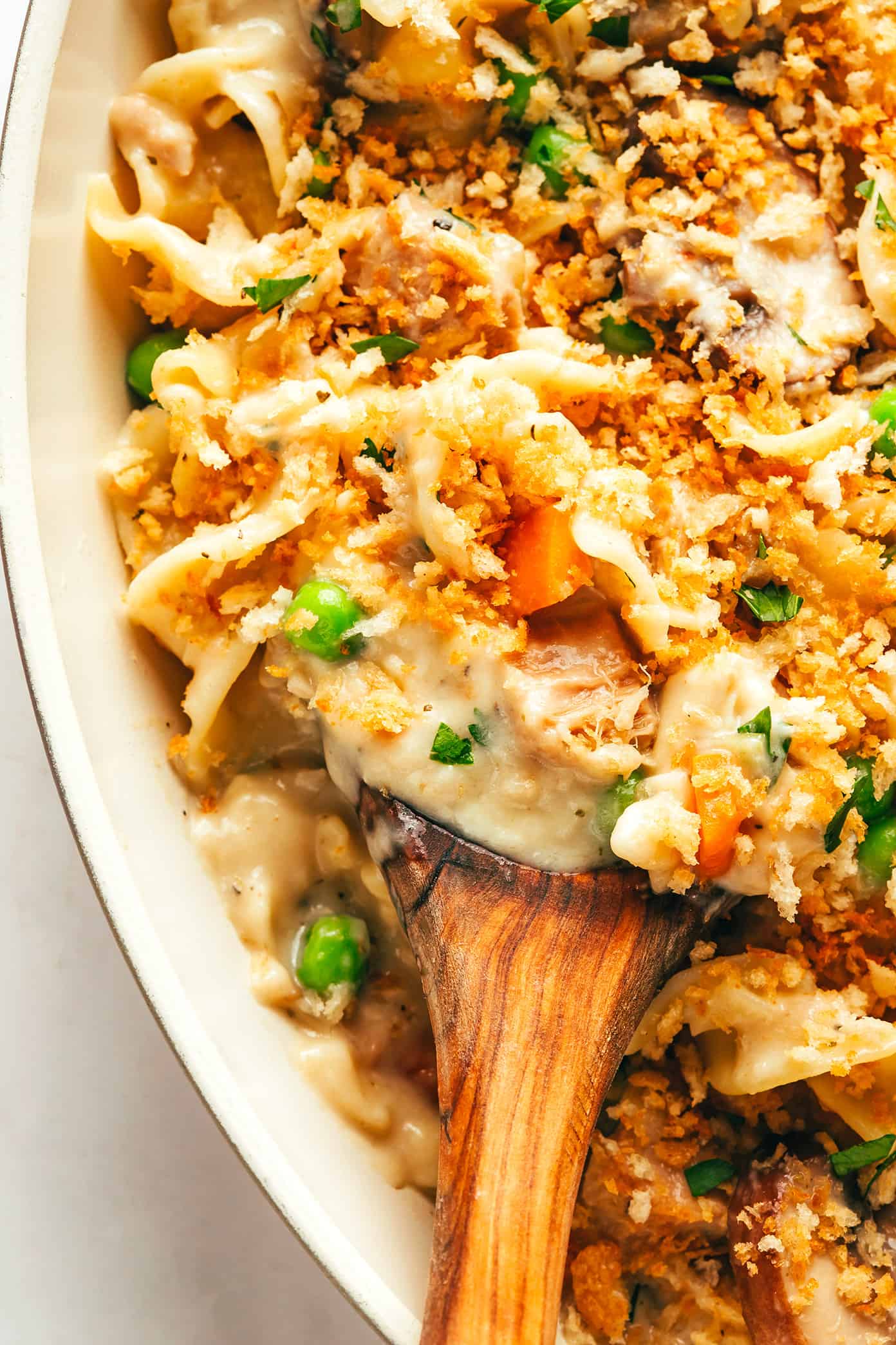 This lightened-up tuna casserole recipe is tossed with a creamy cheddar garlic-herb sauce, lots of veggies, tender egg noodles and a crispy Panko topping. A simple and delicious weeknight dinner recipe that's ready to go in just 40 minutes. | gimmesomeoven.com Tuna Noodle Casserole Closeup