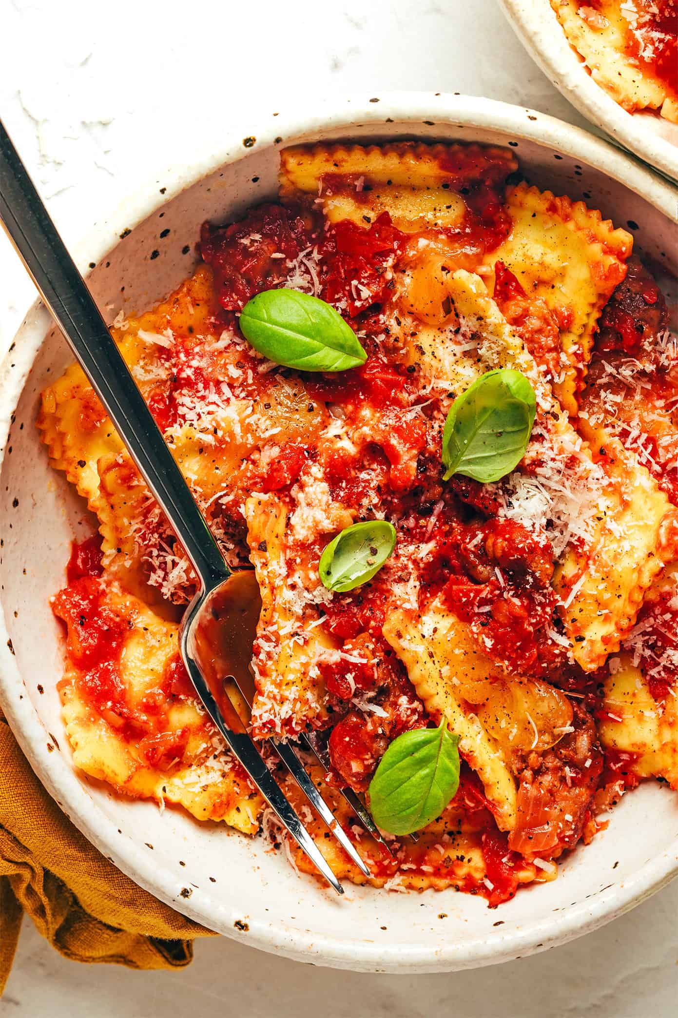 This Italian-inspired ravioli lasagna recipe is easy to make with 8 ingredients and only 15 minutes of hands-on prep time. Feel free to combine Italian sausage with the marinara to make a meat sauce, or omit to make this recipe vegetarian. Always a delicious and easy dinner recipe! | gimmesomeoven.com Ravioli lasagna in bowl with fork