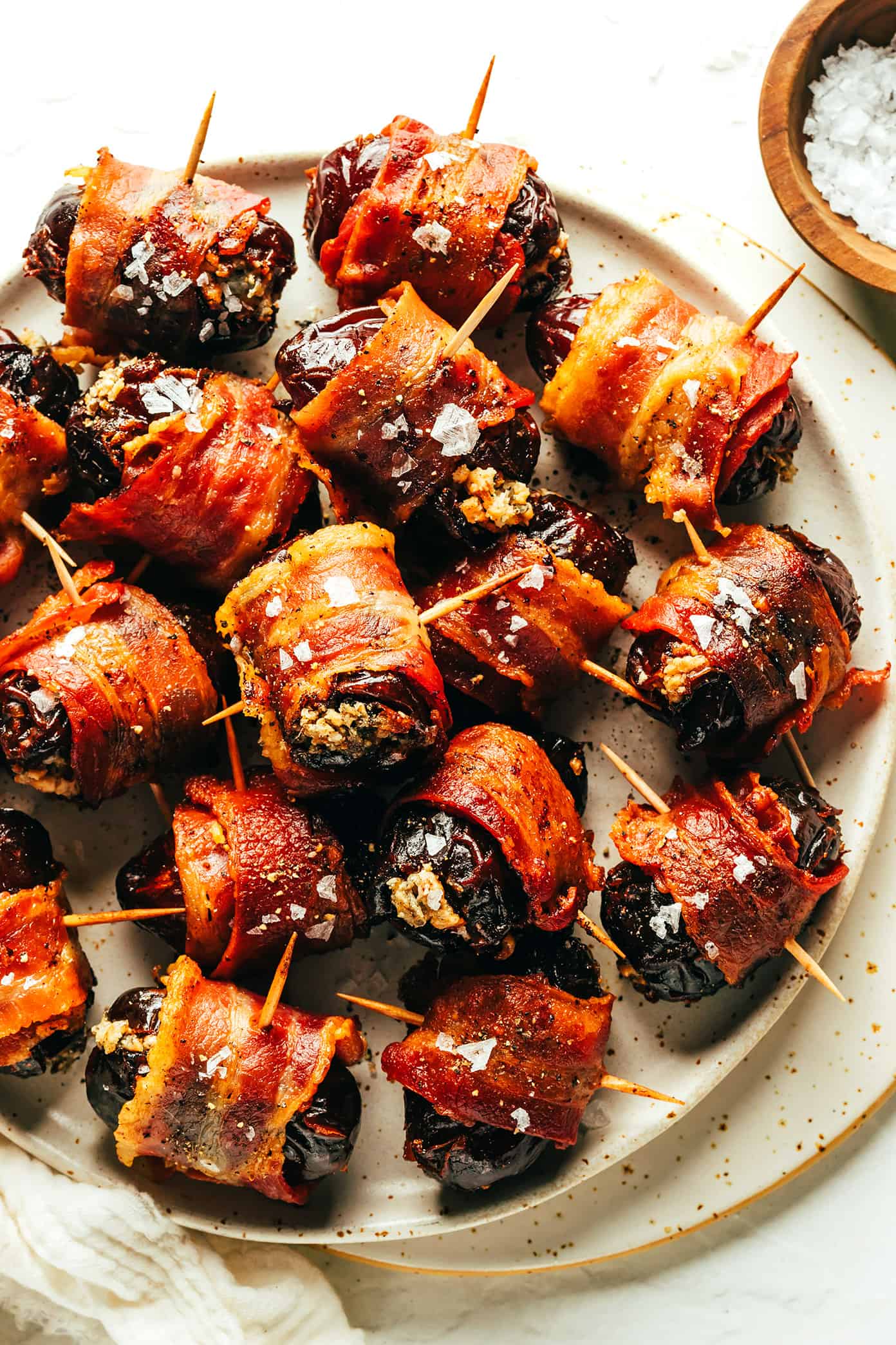 My favorite bacon-wrapped dates recipe is made with crispy bacon, tender Medjool dates, and stuffed with your choice of cheese (blue, feta, goat, cheddar, etc). A delicious appetizer that's easy to make and always a party favorite! | gimmesomeoven.com Bacon Wrapped Dates