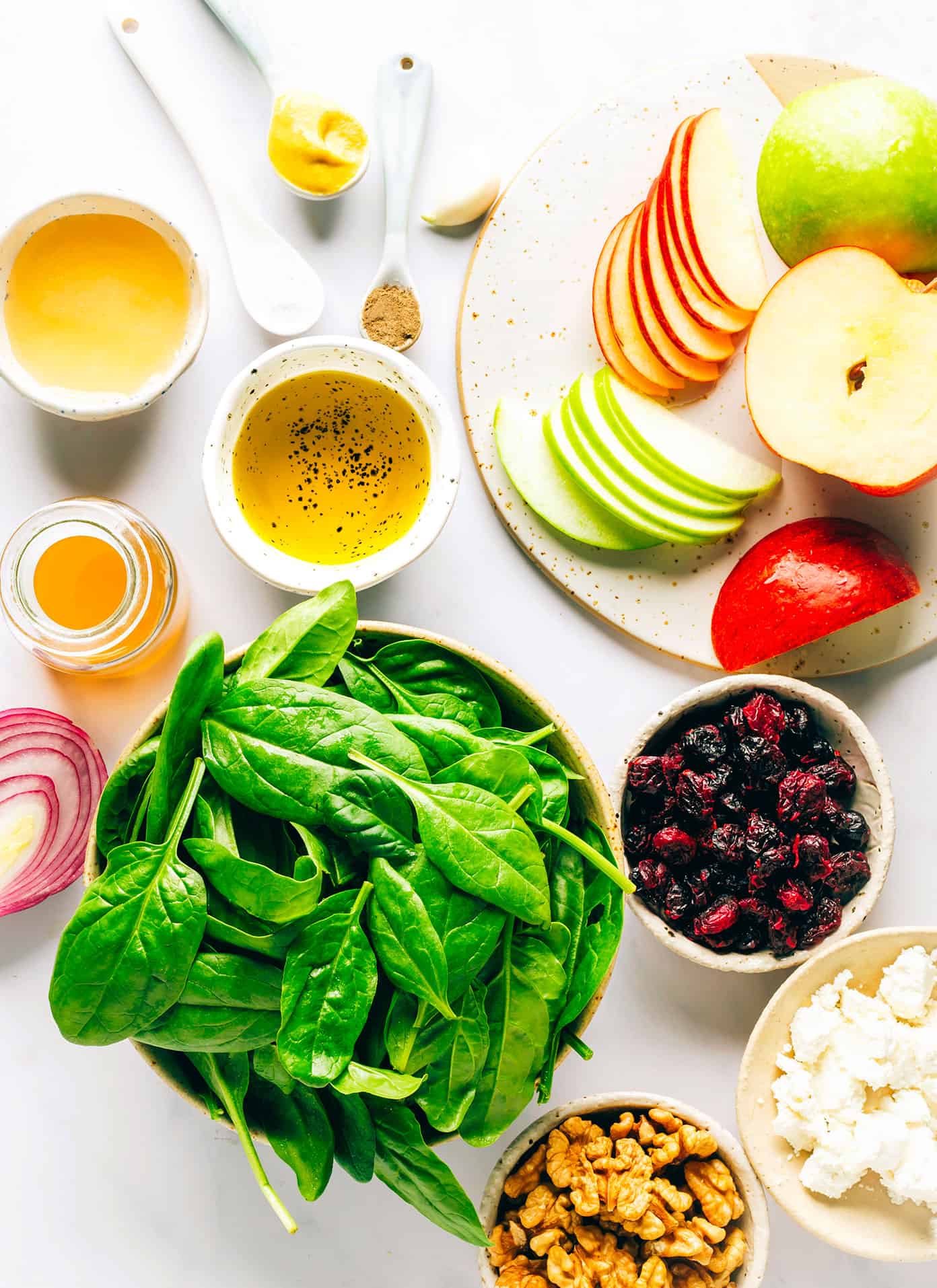 This classic apple spinach salad is tossed with your choice of nuts (walnuts, pecans, or almonds), cheese (blue, feta, goat, or cheddar), dried cranberries, red onions, and a simple vinaigrette. It's the perfect side salad on its own, or feel free to add some protein or avocado to make it an entree! | gimmesomeoven.com Apple Spinach Salad Ingredients