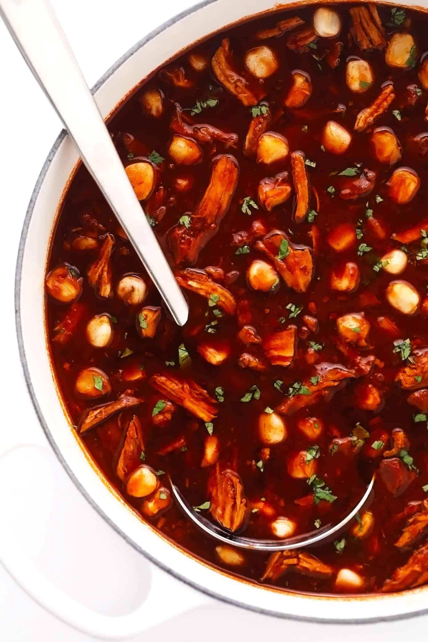 This traditional Mexican pozole recipe is made with tender pork and hominy and simmered in the most delicious chile broth, then piled high with your favorite fresh toppings. Crock-Pot and Instant Pot options for this soup are included too! | gimmesomeoven.com Pot of pork pozole rojo