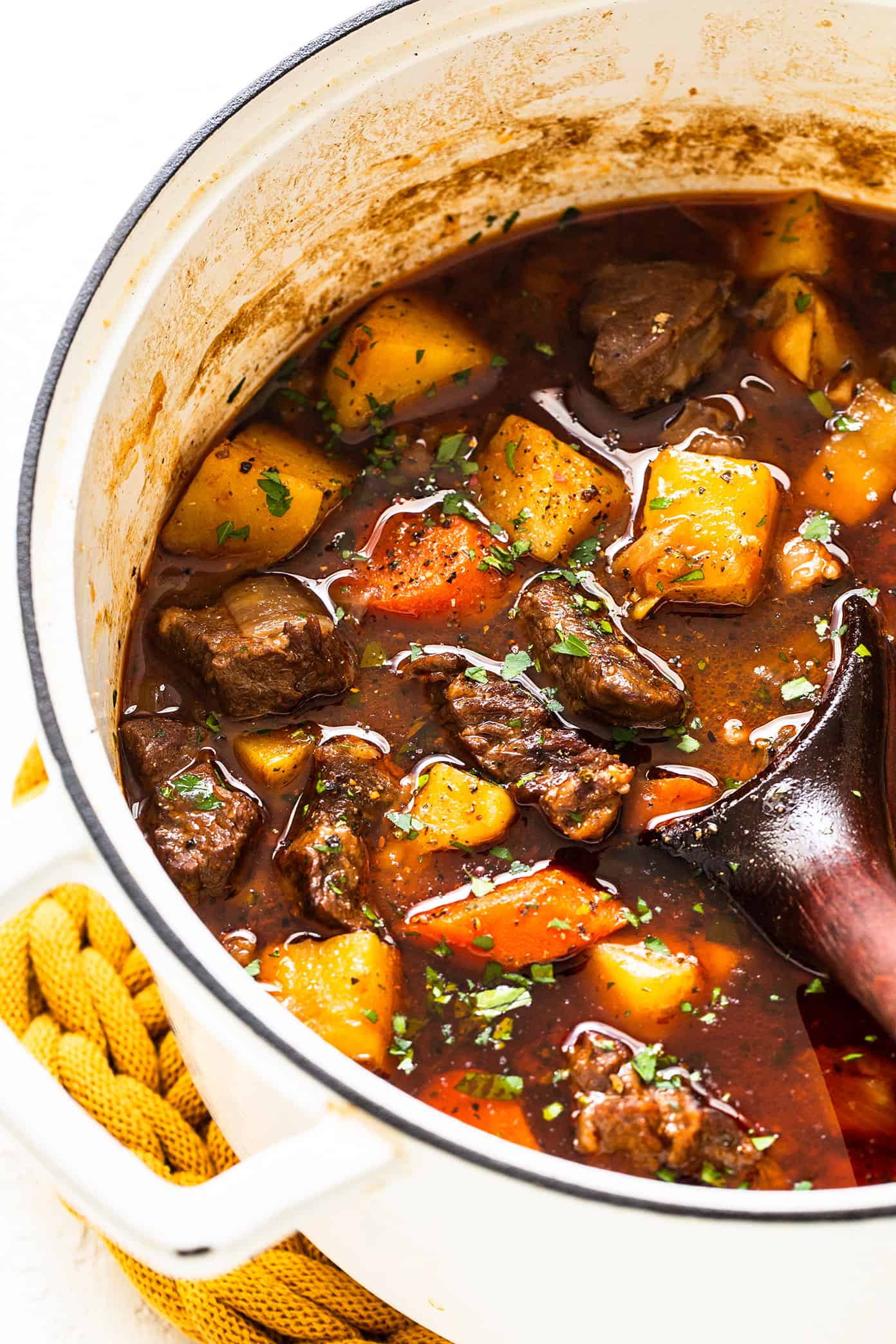 This Guinness Beef Stew recipe is full of tender beef, hearty potatoes, carrots and onions, and a richly-seasoned tomato stout gravy. It's easy to make and the perfect comfort food for St. Patrick's Day or anytime you're craving this Irish-inspired soup. Stovetop, Instant Pot and Crock-Pot options included. | gimmesomeoven.com Guinness Beef Stew in Pot