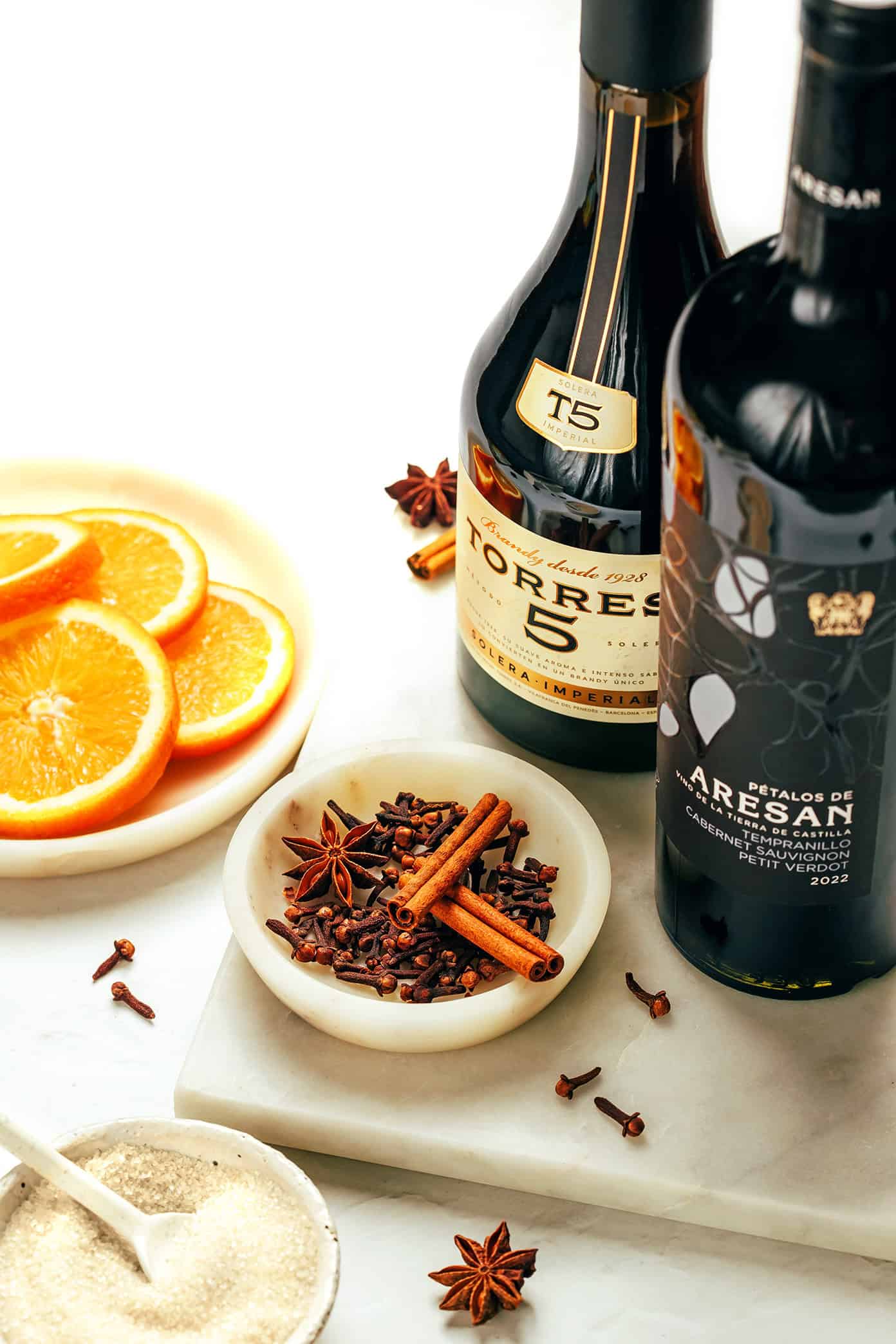 This delicious mulled wine recipe is ready to go in 20 minutes and couldn't be easier to make. Just warm a full-bodied red with brandy (or orange liqueur) and your favorite aromatics (orange, cinnamon, star anise, etc). Then the most delicious hot wine will be yours to enjoy in no time! The perfect easy drink for holiday entertaining. | gimmesomeoven.com Mulled Wine Ingredients