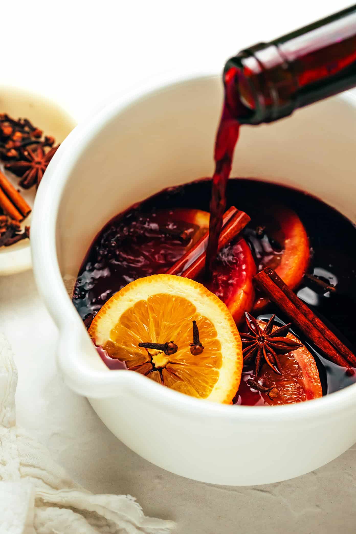 This delicious mulled wine recipe is ready to go in 20 minutes and couldn't be easier to make. Just warm a full-bodied red with brandy (or orange liqueur) and your favorite aromatics (orange, cinnamon, star anise, etc). Then the most delicious hot wine will be yours to enjoy in no time! The perfect easy drink for holiday entertaining. | gimmesomeoven.com How To Make Mulled Wine