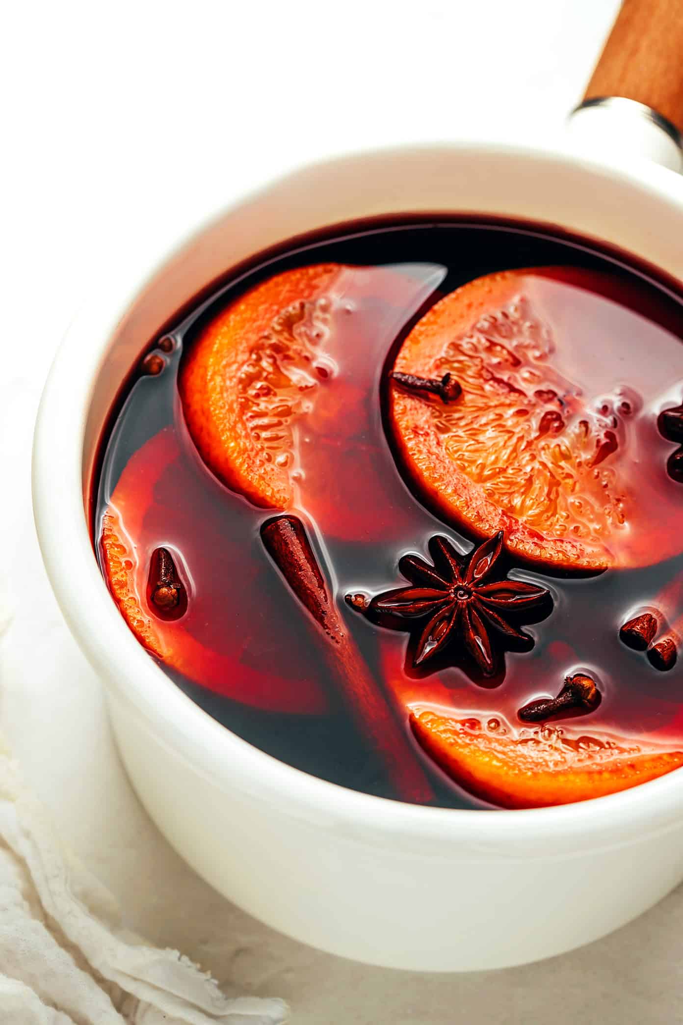 This delicious mulled wine recipe is ready to go in 20 minutes and couldn't be easier to make. Just warm a full-bodied red with brandy (or orange liqueur) and your favorite aromatics (orange, cinnamon, star anise, etc). Then the most delicious hot wine will be yours to enjoy in no time! The perfect easy drink for holiday entertaining. | gimmesomeoven.com Mulled Wine in Saucepan