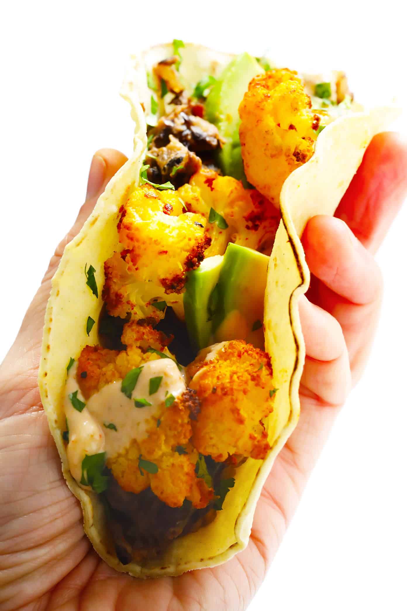 These Roasted Cauliflower and Black Bean Tacos are naturally vegetarian, vegan and gluten-free, they're topped with avocado, cilantro, and a zesty cumin lime crema, and they are SO delicious! | Gimme Some Oven #cauliflower #tacos #healthy #dinner #recipe #vegetarian #glutenfree Vegan Roasted Cauliflower and Black Bean Tacos