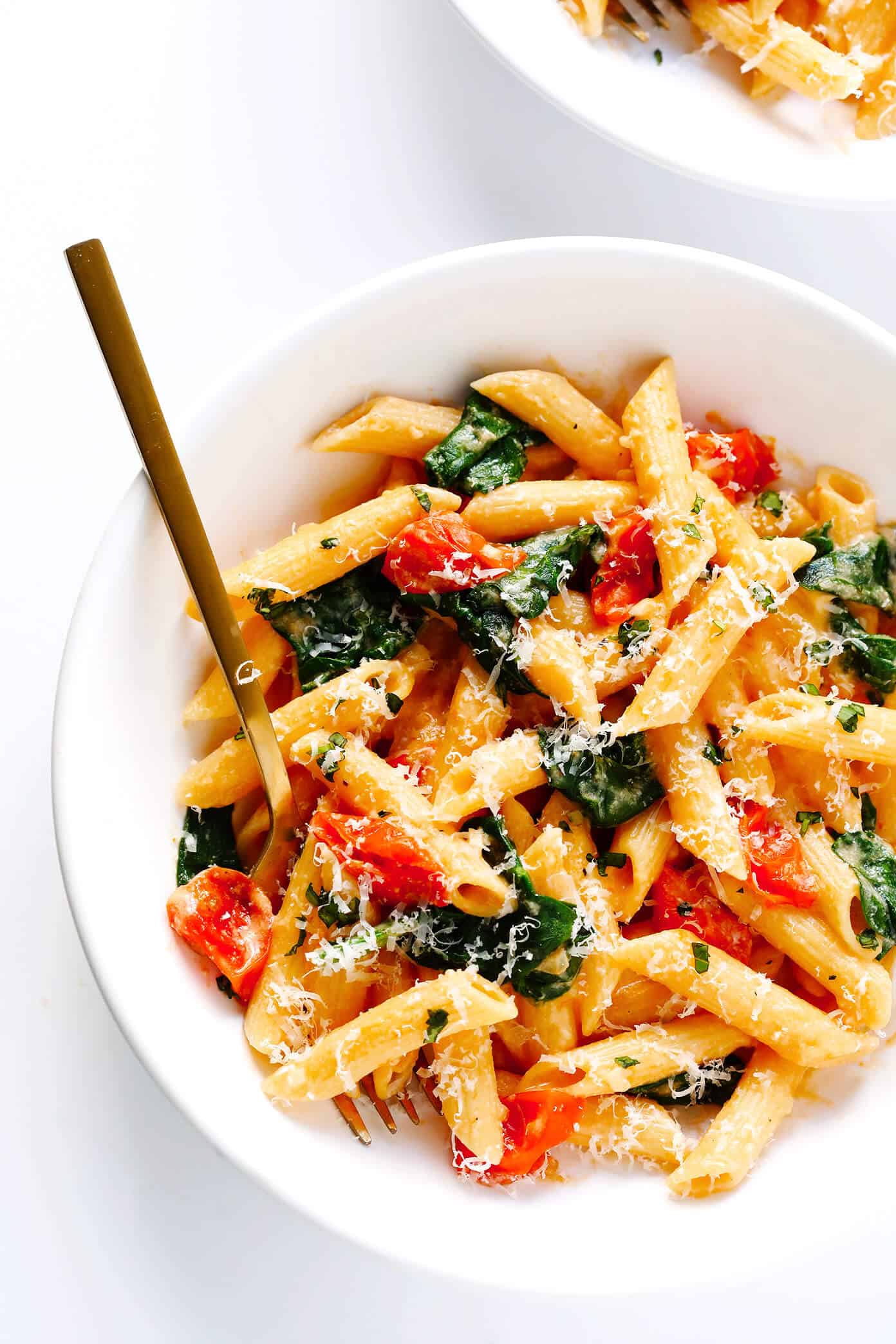 This Creamy Rosé Pasta is tossed with juicy roasted tomatoes, spinach, and a heavenly creamy garlicky rosé wine sauce (made without heavy cream). Total comfort food, and totally delicious. | Gimme Some Oven #pastarecipes #rosé #dinnerrecipes #valentinesday Creamy Rosé Wine Pasta with Roasted Tomatoes and Spinach in bowl