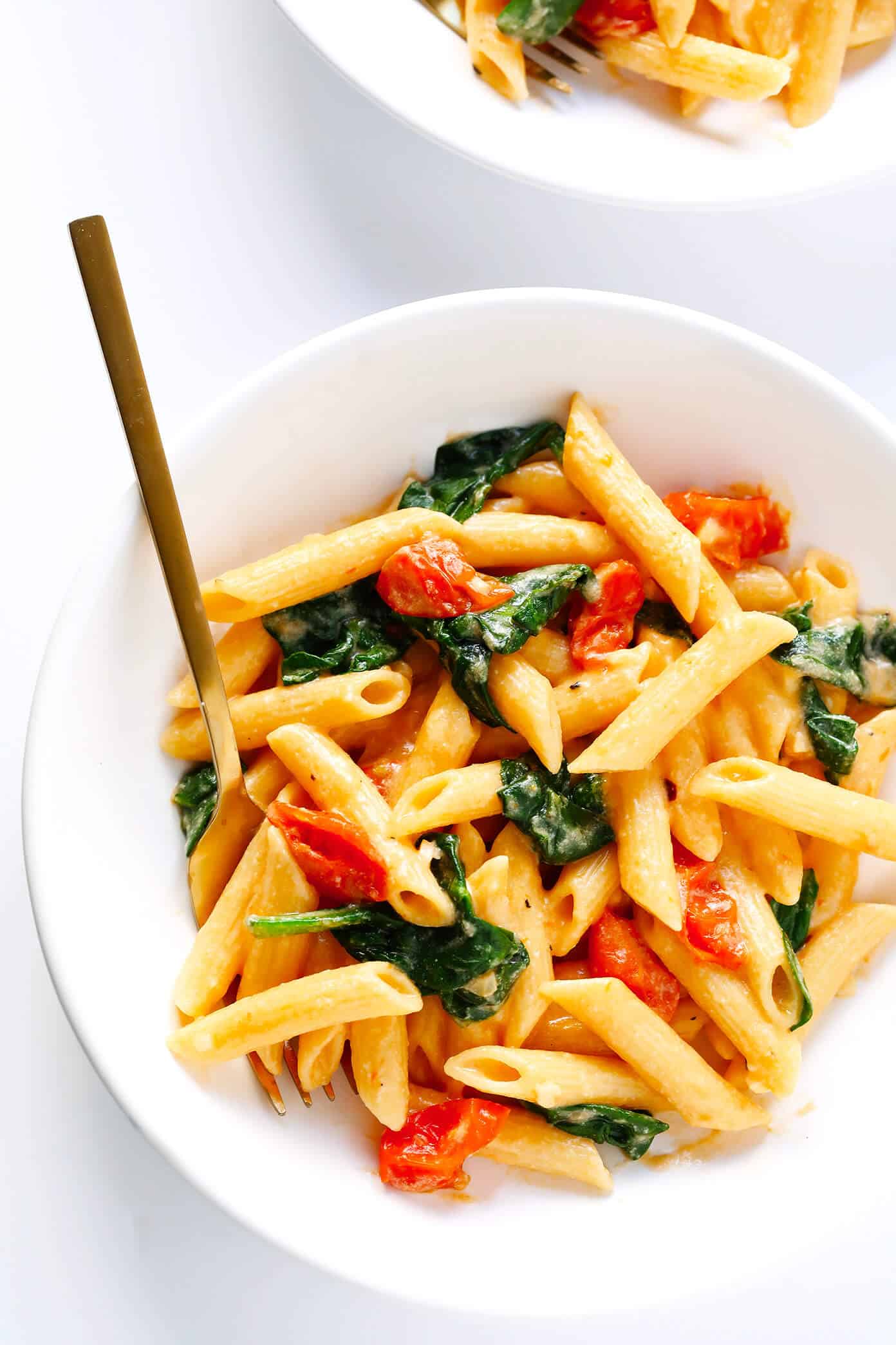 This Creamy Rosé Pasta is tossed with juicy roasted tomatoes, spinach, and a heavenly creamy garlicky rosé wine sauce (made without heavy cream). Total comfort food, and totally delicious. | Gimme Some Oven #pastarecipes #rosé #dinnerrecipes #valentinesday Creamy Rosé Pasta with Roasted Tomatoes and Spinach