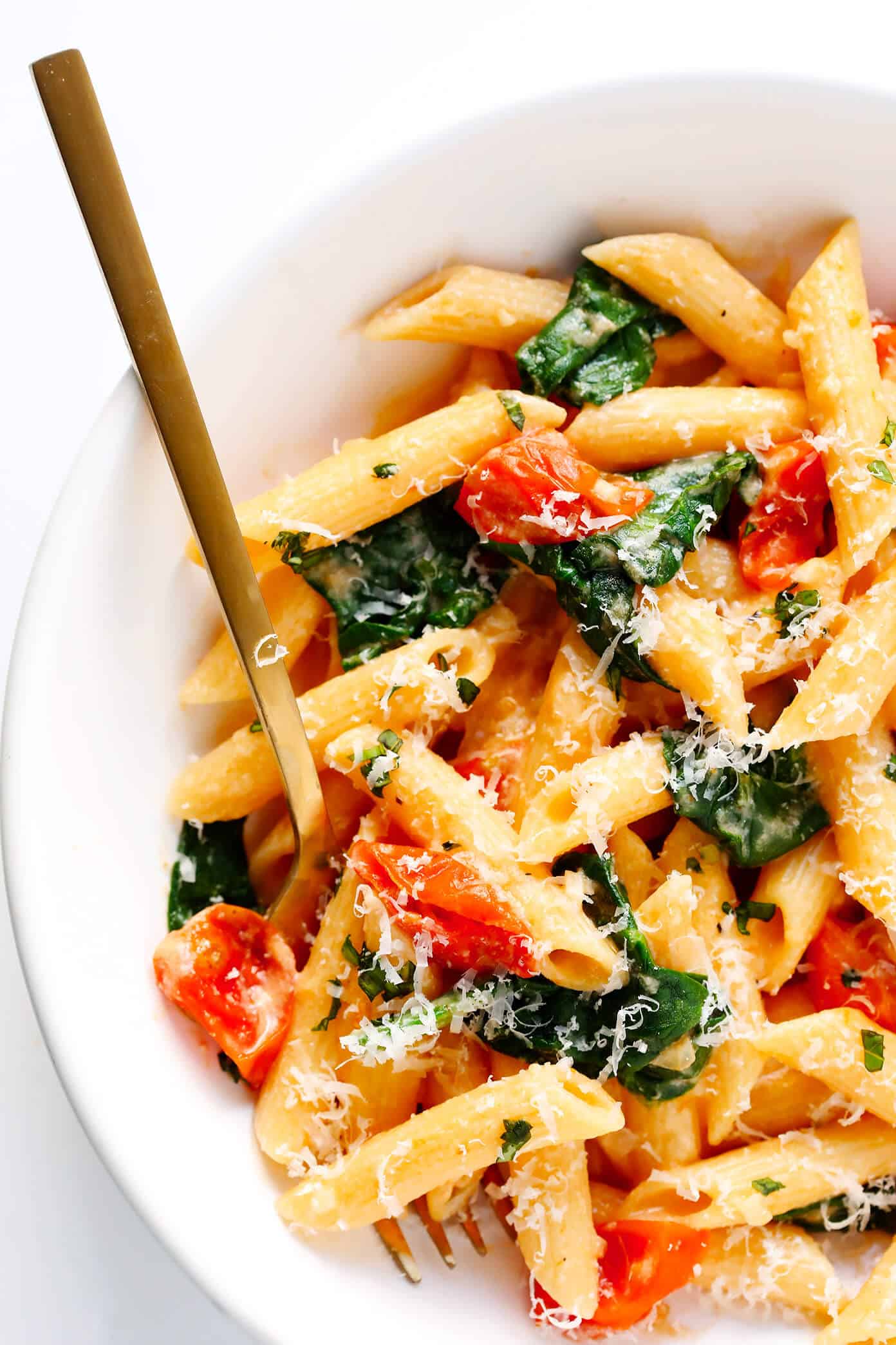 This Creamy Rosé Pasta is tossed with juicy roasted tomatoes, spinach, and a heavenly creamy garlicky rosé wine sauce (made without heavy cream). Total comfort food, and totally delicious. | Gimme Some Oven #pastarecipes #rosé #dinnerrecipes #valentinesday Creamy Rosé Pasta with Roasted Tomatoes and Spinach in bowl
