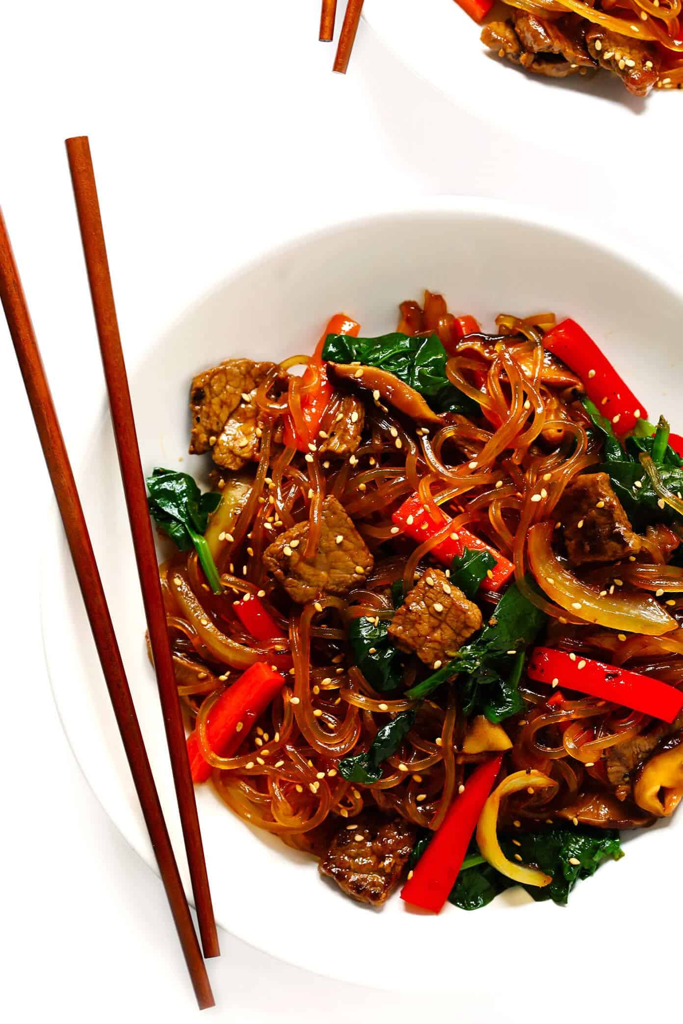 This Japchae (Korean noodle stir-fry) recipe is easy to make in just 30 minutes. It can be customized with your choice of veggies and protein (beef, chicken, shrimp, or tofu). And it is SO delicious! | gimmesomeoven.com #korean #noodle #stirfry #saute #pasta #beef #glutenfree #vegetarian #vegan #asian #dinner #mealprep #healthy Japchae with beef and veggies