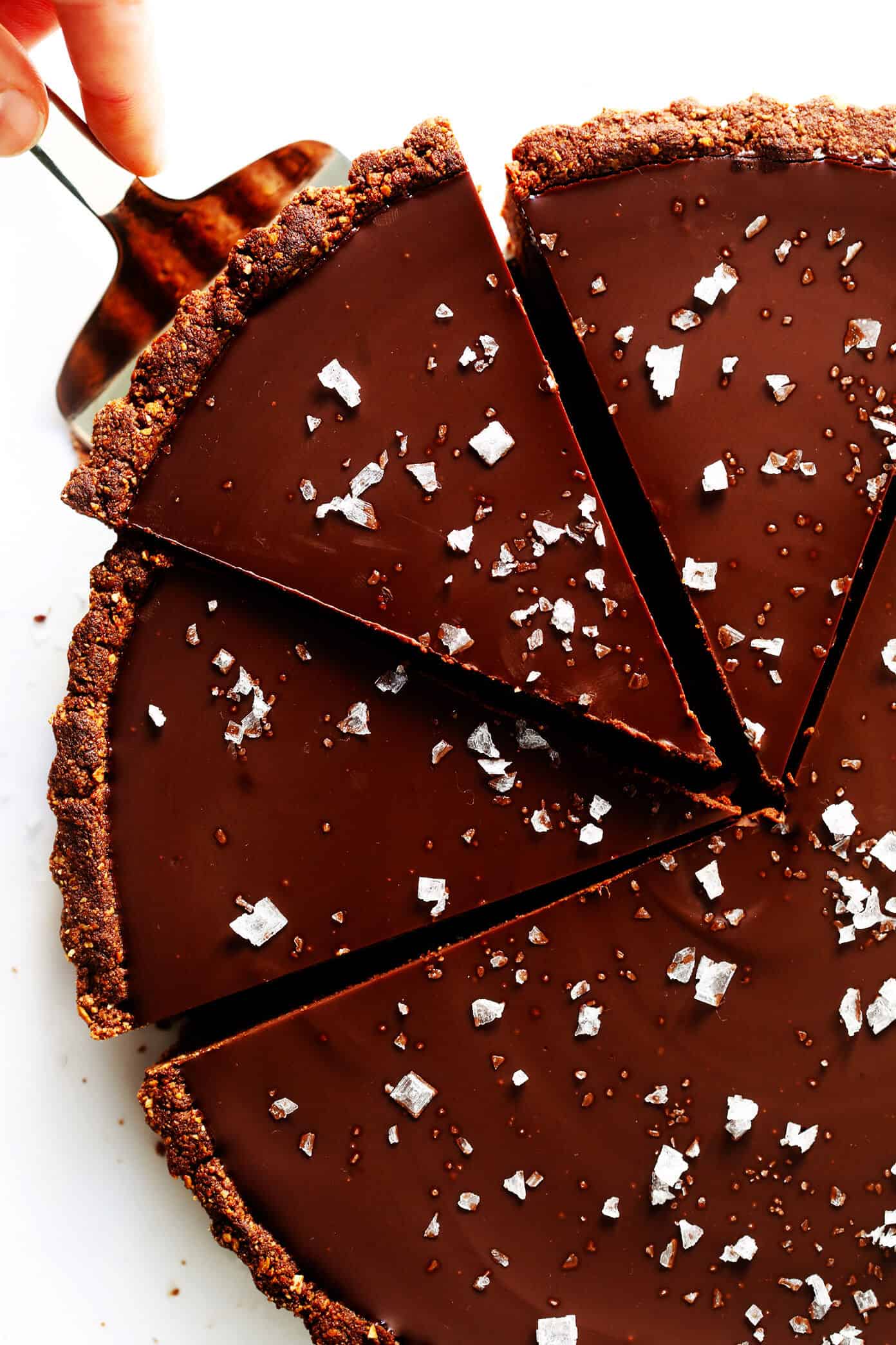 LOVE this Salted Dark Chocolate Tart recipe! It's quick and easy to make ahead, made with a gluten-free almond crust and zero heavy cream, and it's SO decadent and delicious. The perfect dessert for Valentine's Day or anytime you're craving some chocolate. | Gimme Some Oven #chocolate #tart #darkchocolate #dessert #sweets #valentines #glutenfree #vegan #vegetarian Salted Dark Chocolate Tart Recipe
