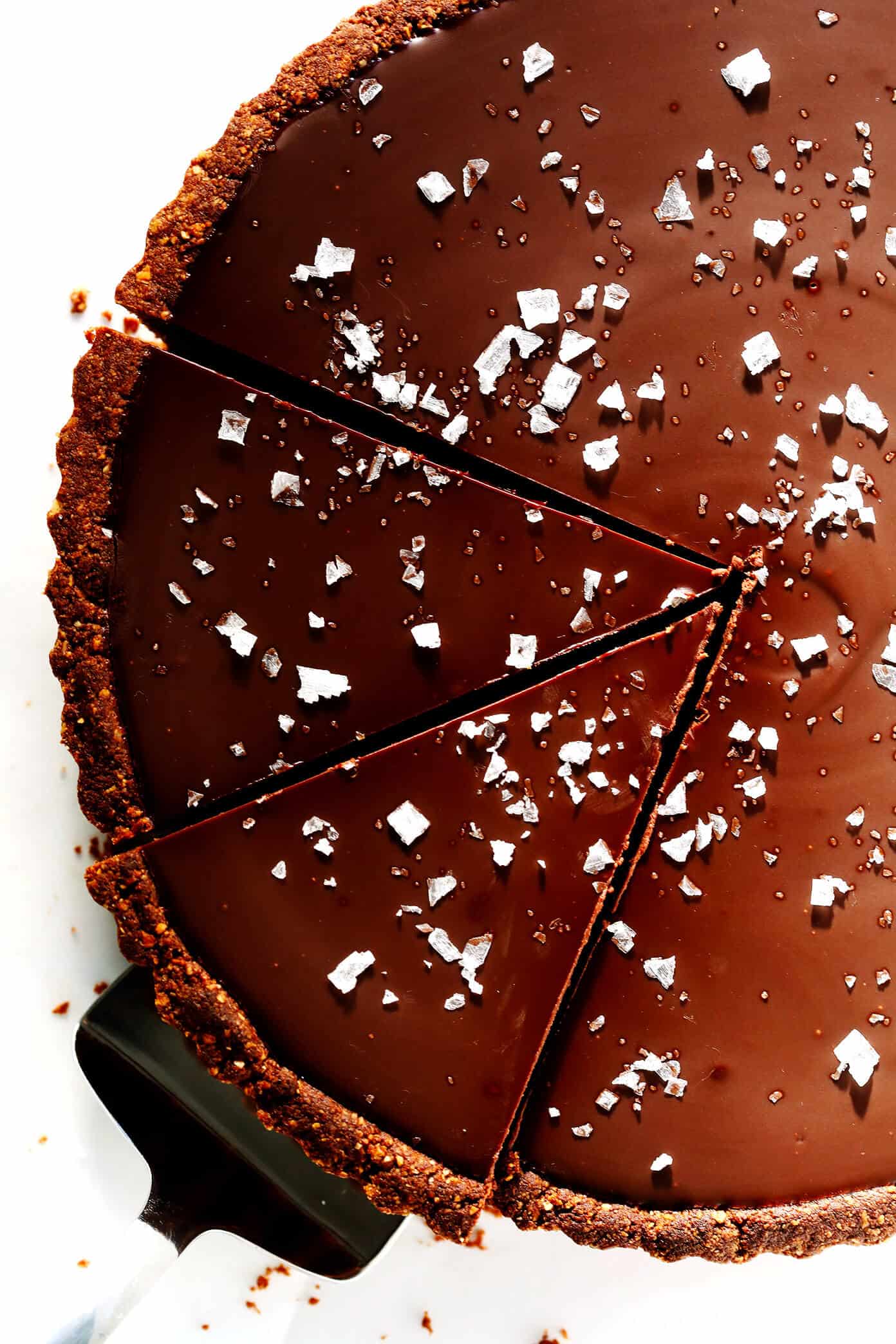 LOVE this Salted Dark Chocolate Tart recipe! It's quick and easy to make ahead, made with a gluten-free almond crust and zero heavy cream, and it's SO decadent and delicious. The perfect dessert for Valentine's Day or anytime you're craving some chocolate. | Gimme Some Oven #chocolate #tart #darkchocolate #dessert #sweets #valentines #glutenfree #vegan #vegetarian Salted Dark Chocolate Tart