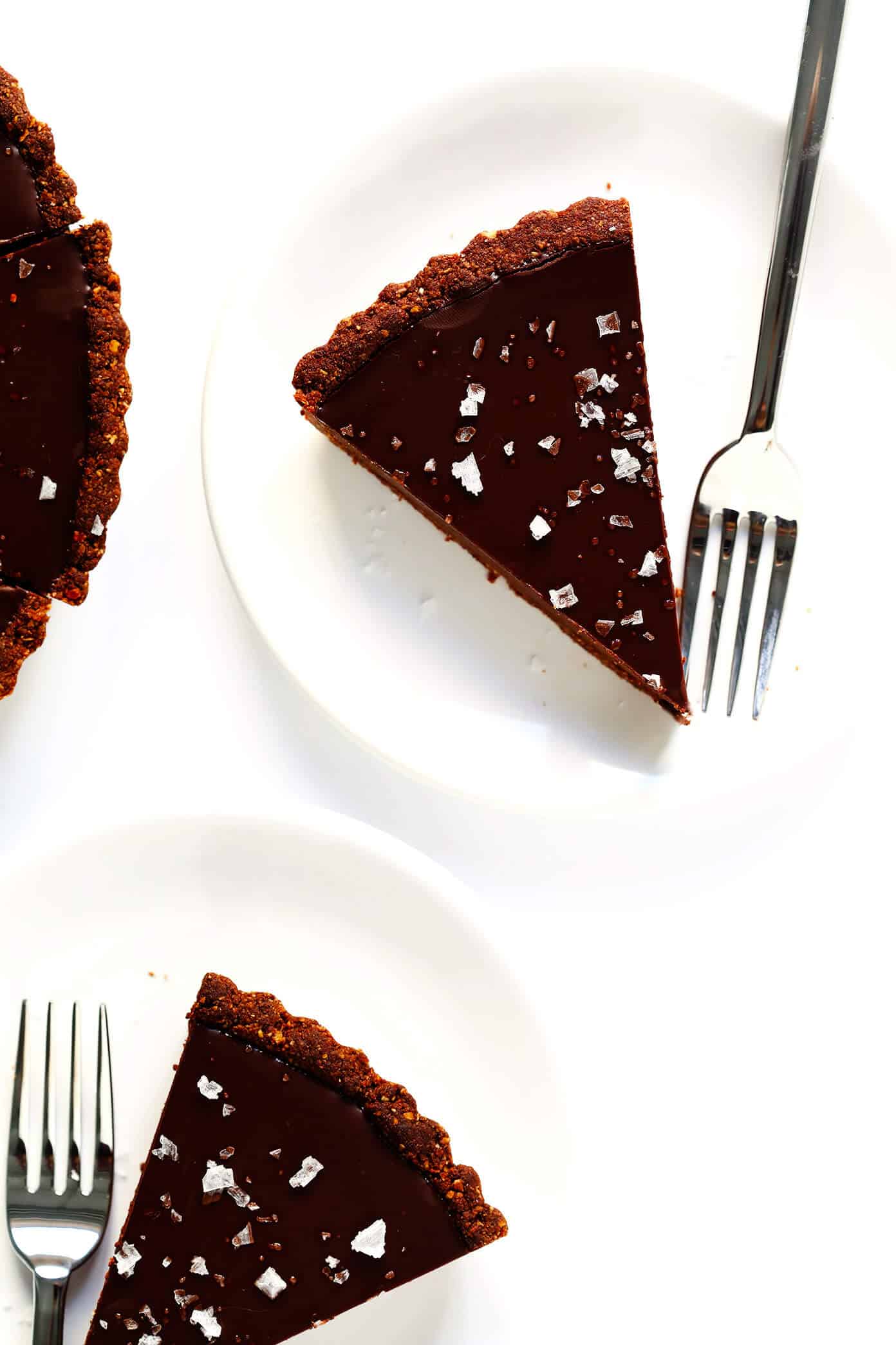 LOVE this Salted Dark Chocolate Tart recipe! It's quick and easy to make ahead, made with a gluten-free almond crust and zero heavy cream, and it's SO decadent and delicious. The perfect dessert for Valentine's Day or anytime you're craving some chocolate. | Gimme Some Oven #chocolate #tart #darkchocolate #dessert #sweets #valentines #glutenfree #vegan #vegetarian Gluten-Free Chocolate Tart (Vegan)