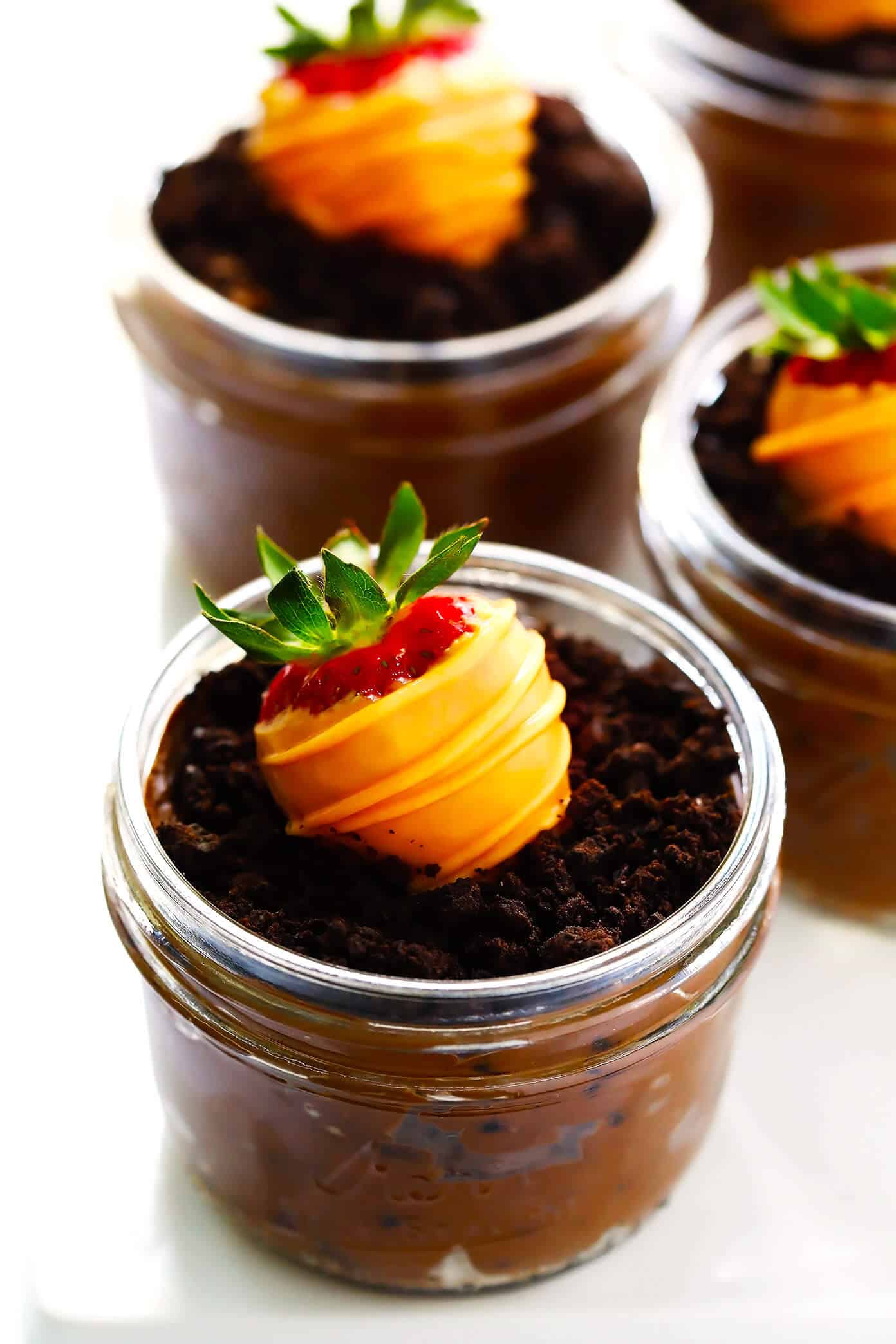 Love these Carrot Patch "Dirt" Cups! They're made with a chocolate avocado mousse pudding "dirt cake", chocolate-covered strawberry "carrots", and a sprinkling of Oreos, and they are SO delicious and fun! The perfect Spring (or Easter!) dessert that kids and adults will love alike. | Gimme Some Oven #dirtcake #easter #spring #chocolate #dessert #treats Carrot Patch Dirt Cups with Chocolate-Covered Strawberries