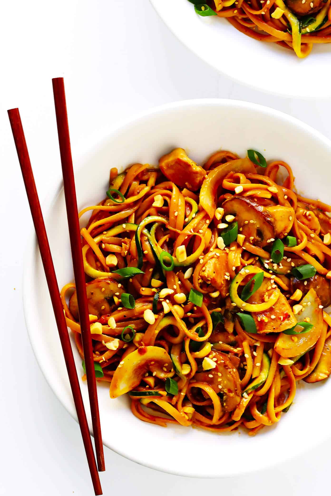 This Kung Pao Chicken Noodle Stir-Fry recipe is quick and easy to make, easy to customize with your favorite veggies (I used zoodles, mushrooms and onions) and/or proteins (shrimp, pork, beef or tofu would also work well!), and it's tossed with the most DELICIOUS zesty peanut sauce. Feel free to make it as spicy or mild as you'd like! | Gimme Some Oven #kungpaochicken #chickennoodle #stirfry #dinnerrecipes #easyrecipes Kung Pao Chicken Noodle Stir-Fry recipe