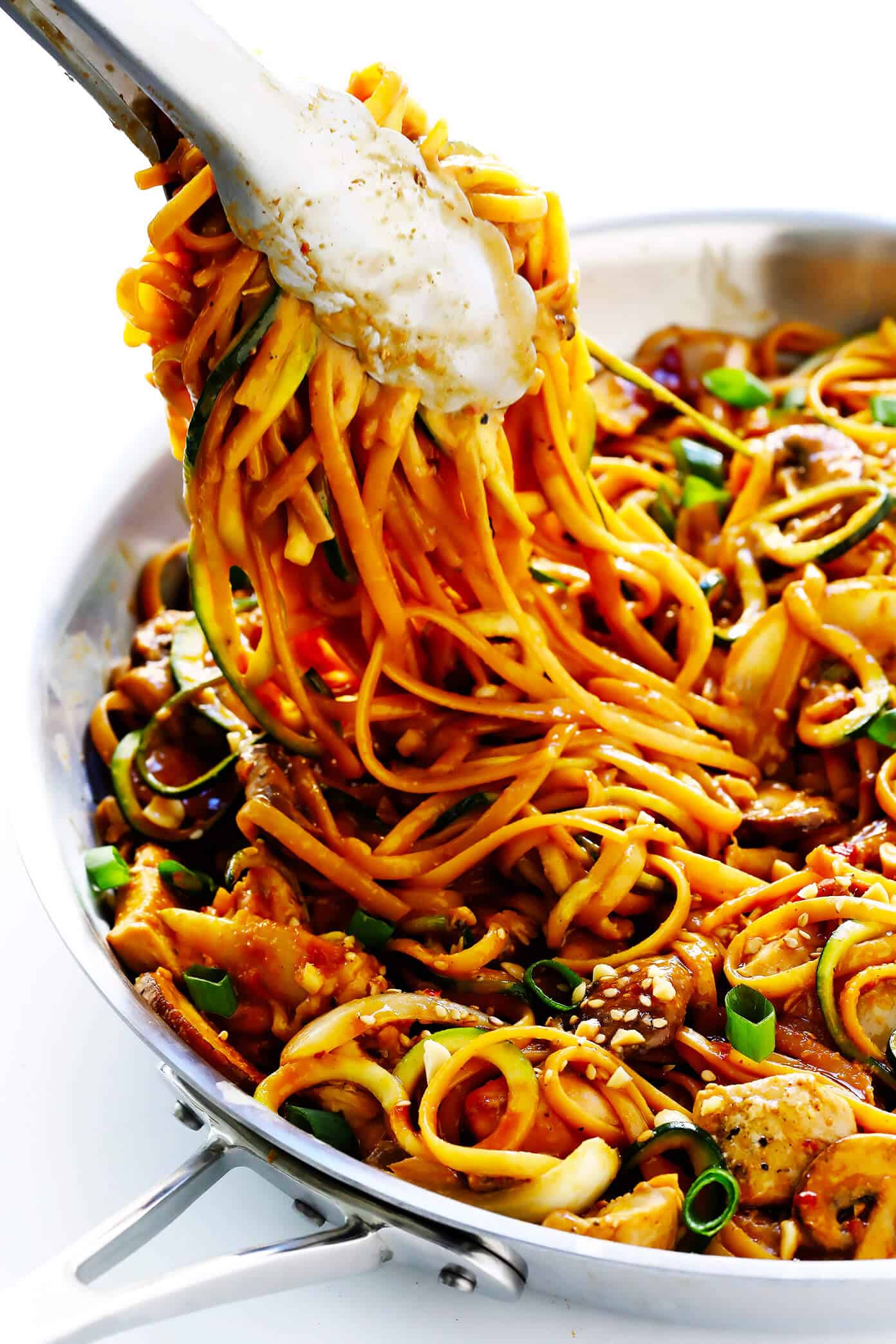 This Kung Pao Chicken Noodle Stir-Fry recipe is quick and easy to make, easy to customize with your favorite veggies (I used zoodles, mushrooms and onions) and/or proteins (shrimp, pork, beef or tofu would also work well!), and it's tossed with the most DELICIOUS zesty peanut sauce. Feel free to make it as spicy or mild as you'd like! | Gimme Some Oven #kungpaochicken #chickennoodle #stirfry #dinnerrecipes #easyrecipes Kung Pao Chicken Noodle Stir-Fry