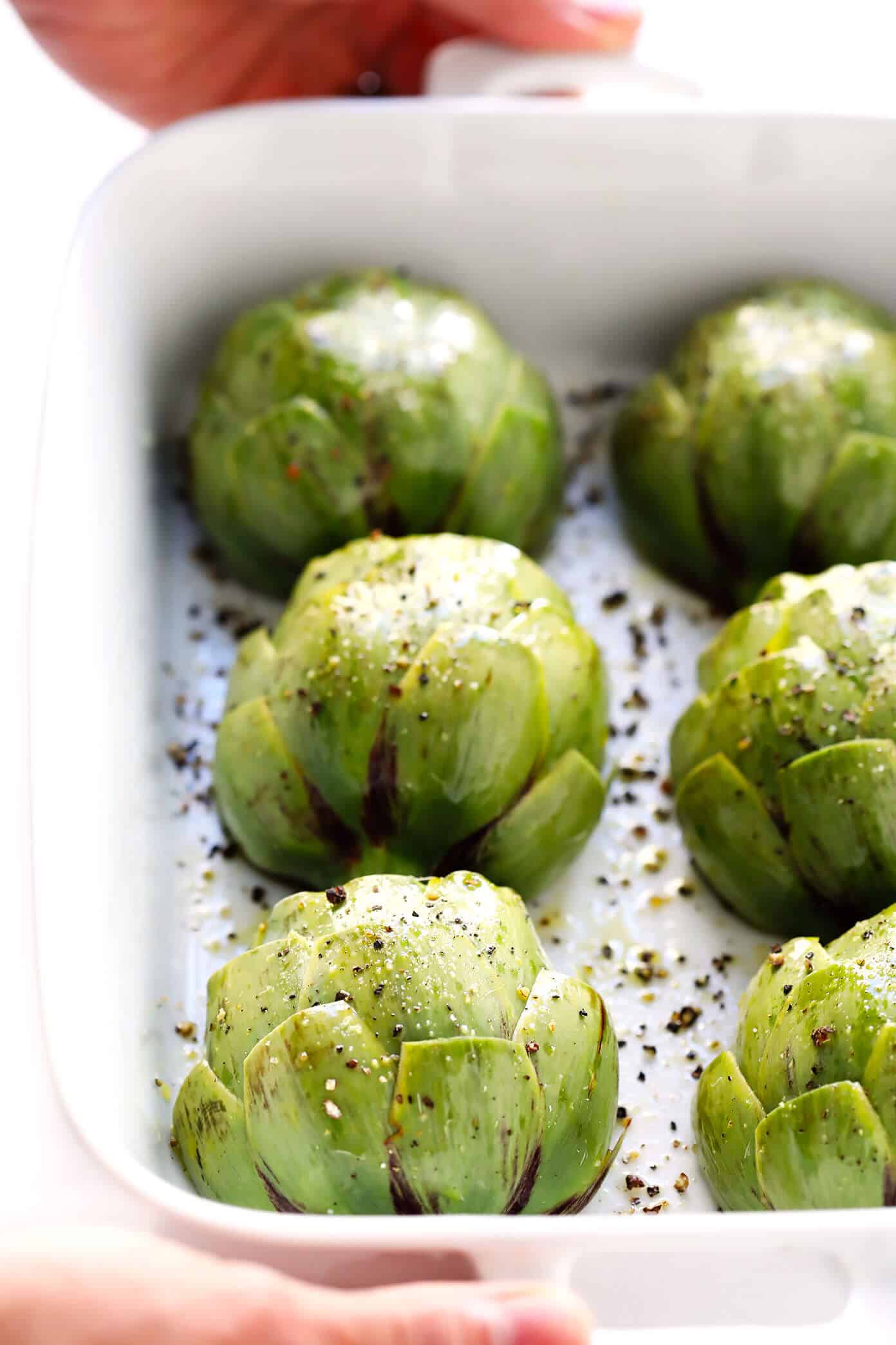 Seriously the most amazing roasted artichokes recipe! They're stuffed with lots of garlic and herbs, seasoned with lots of lemon and black pepper, and roasted to crispy, tender perfection. The perfect vegetable side dish! | Gimme Some Oven #artichokes #roasted #sidedish #vegetable #glutenfree #vegan How To Make Roasted Artichokes
