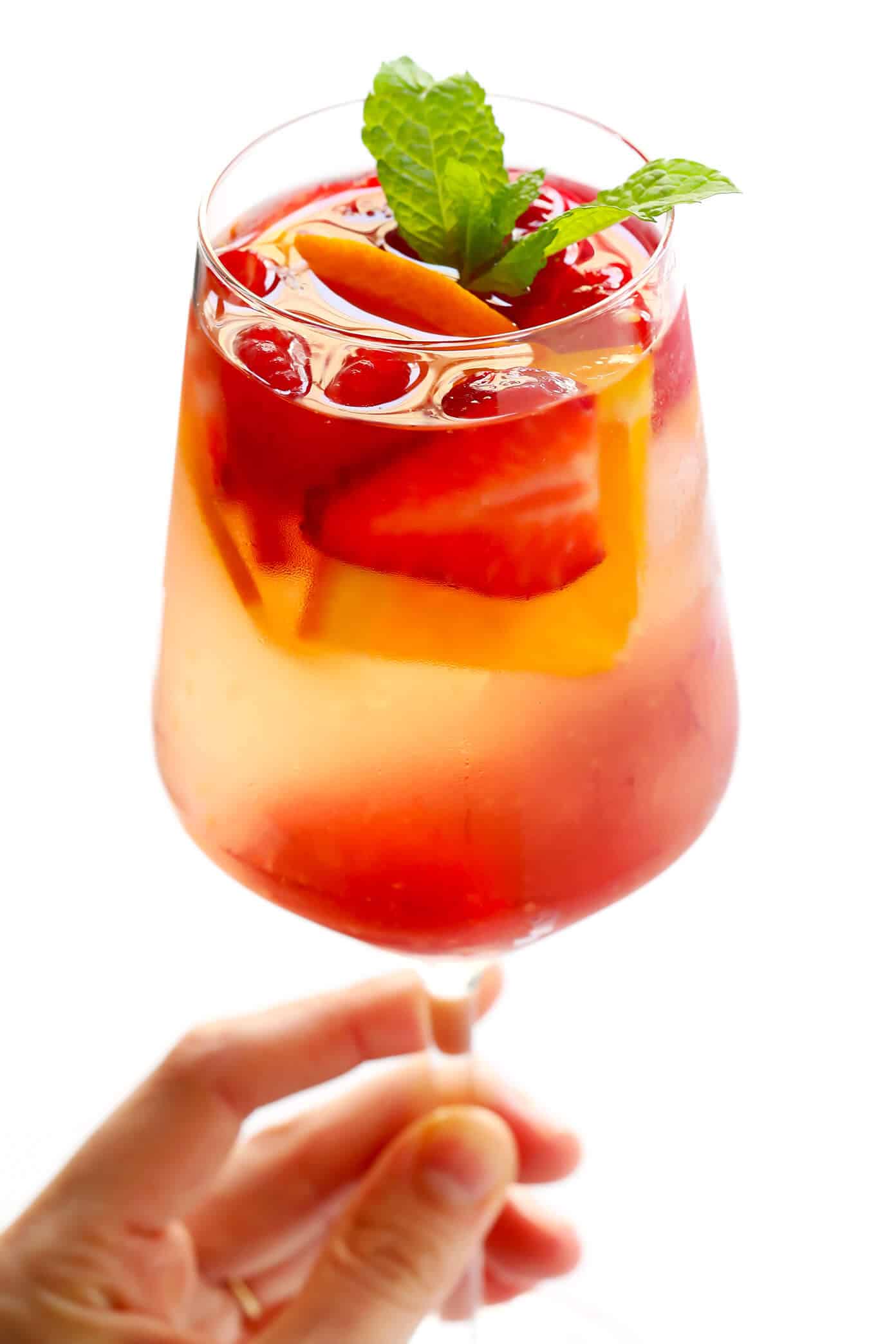 This lovely Rosy Rosé Sangria recipe is made with crisp rosé wine, your choice of fresh fruit (strawberry, raspberry, peach, etc.), and finished off with a subtle floral hint of rose water. It's perfect for brunch, happy hour, or summer dinner parties, and so refreshing and delicious! | Gimme Some Oven #sangria #rose #wine #summer #cocktail Rosy Rosé Sangria Recipe