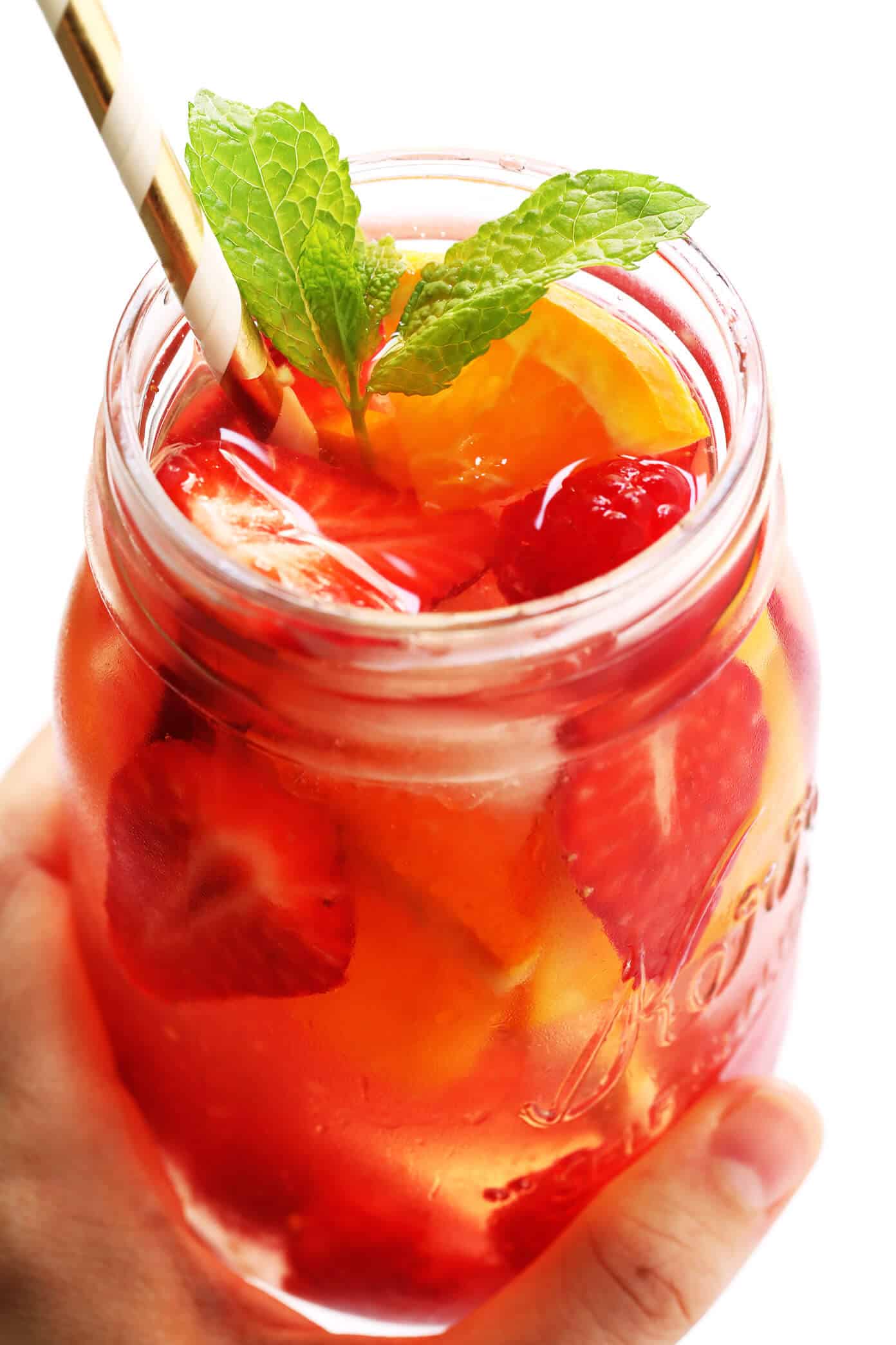 This lovely Rosy Rosé Sangria recipe is made with crisp rosé wine, your choice of fresh fruit (strawberry, raspberry, peach, etc.), and finished off with a subtle floral hint of rose water. It's perfect for brunch, happy hour, or summer dinner parties, and so refreshing and delicious! | Gimme Some Oven #sangria #rose #wine #summer #cocktail Rosé Sangria Recipe