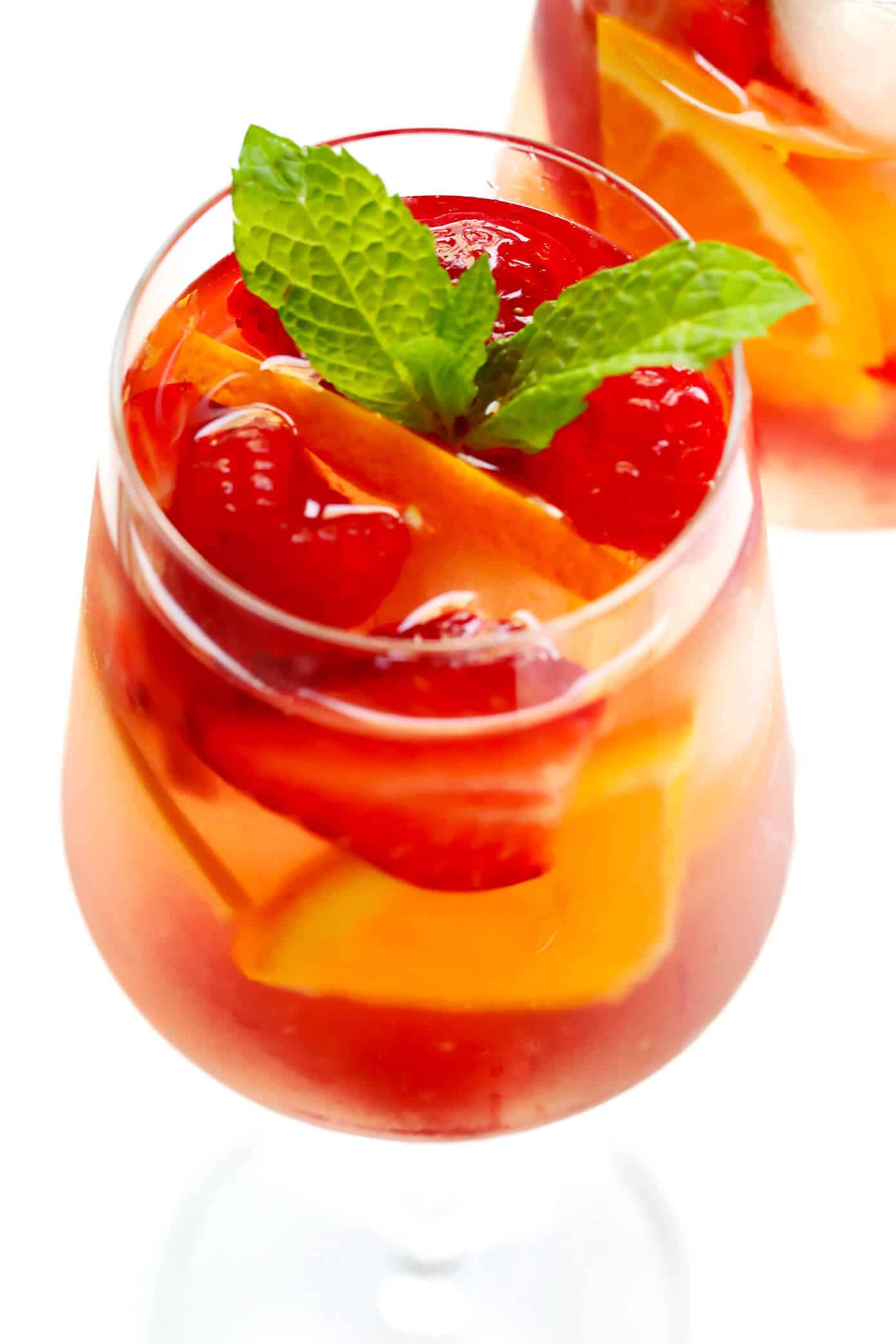 This lovely Rosy Rosé Sangria recipe is made with crisp rosé wine, your choice of fresh fruit (strawberry, raspberry, peach, etc.), and finished off with a subtle floral hint of rose water. It's perfect for brunch, happy hour, or summer dinner parties, and so refreshing and delicious! | Gimme Some Oven #sangria #rose #wine #summer #cocktail Strawberry Rosy Rosé Sangria