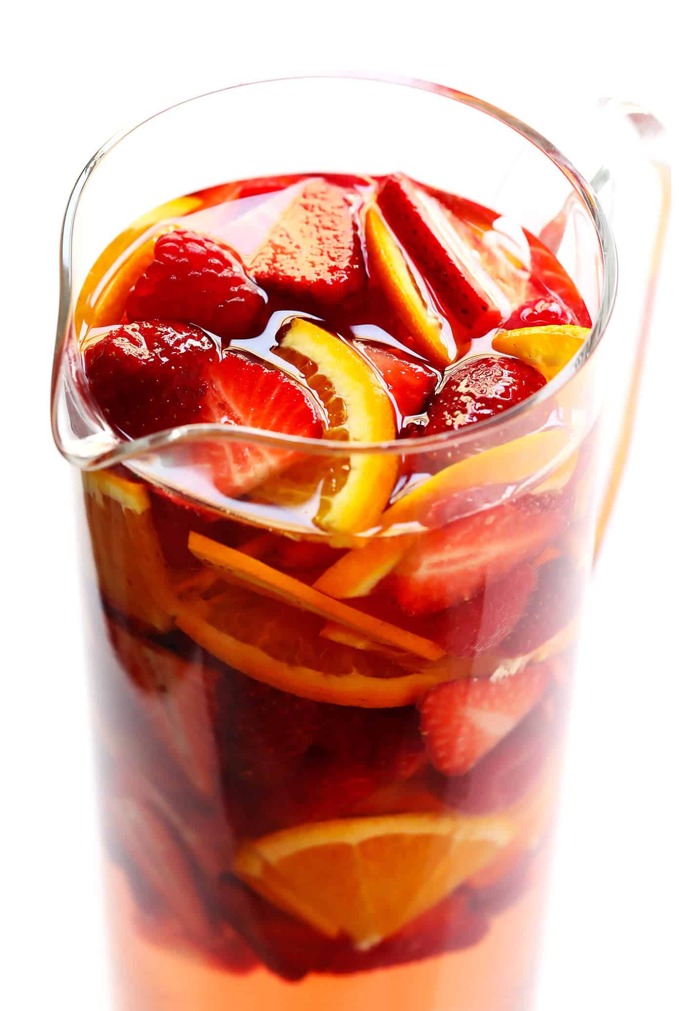 This lovely Rosy Rosé Sangria recipe is made with crisp rosé wine, your choice of fresh fruit (strawberry, raspberry, peach, etc.), and finished off with a subtle floral hint of rose water. It's perfect for brunch, happy hour, or summer dinner parties, and so refreshing and delicious! | Gimme Some Oven #sangria #rose #wine #summer #cocktail How to make sangria with rosé wine