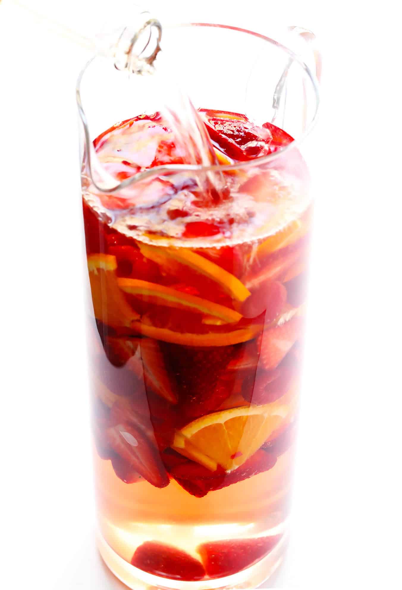 This lovely Rosy Rosé Sangria recipe is made with crisp rosé wine, your choice of fresh fruit (strawberry, raspberry, peach, etc.), and finished off with a subtle floral hint of rose water. It's perfect for brunch, happy hour, or summer dinner parties, and so refreshing and delicious! | Gimme Some Oven #sangria #rose #wine #summer #cocktail How to make sangria