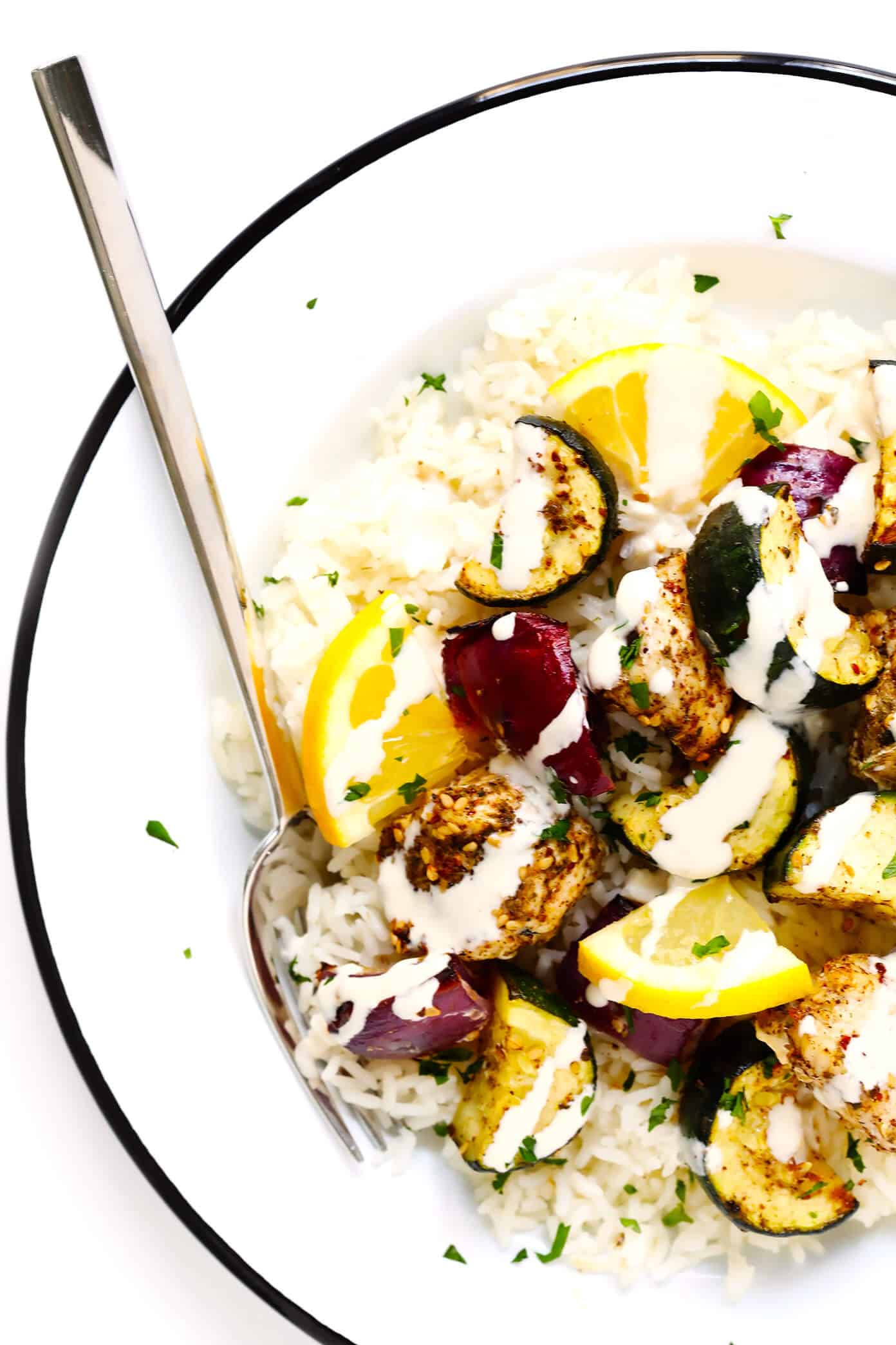 This easy Za'atar Chicken and Vegetable Kabobs recipe is easy to make with your favorite kind of veggies, and tossed with the most delicious lemon za'atar seasoning. Perfect for the grill or roasting in the oven, and naturally gluten-free. | Gimme Some Oven #zaatar #chicken #kabobs #skewers #vegetables Za'atar Chicken and Vegetable Kabobs over rice with tahini dressing