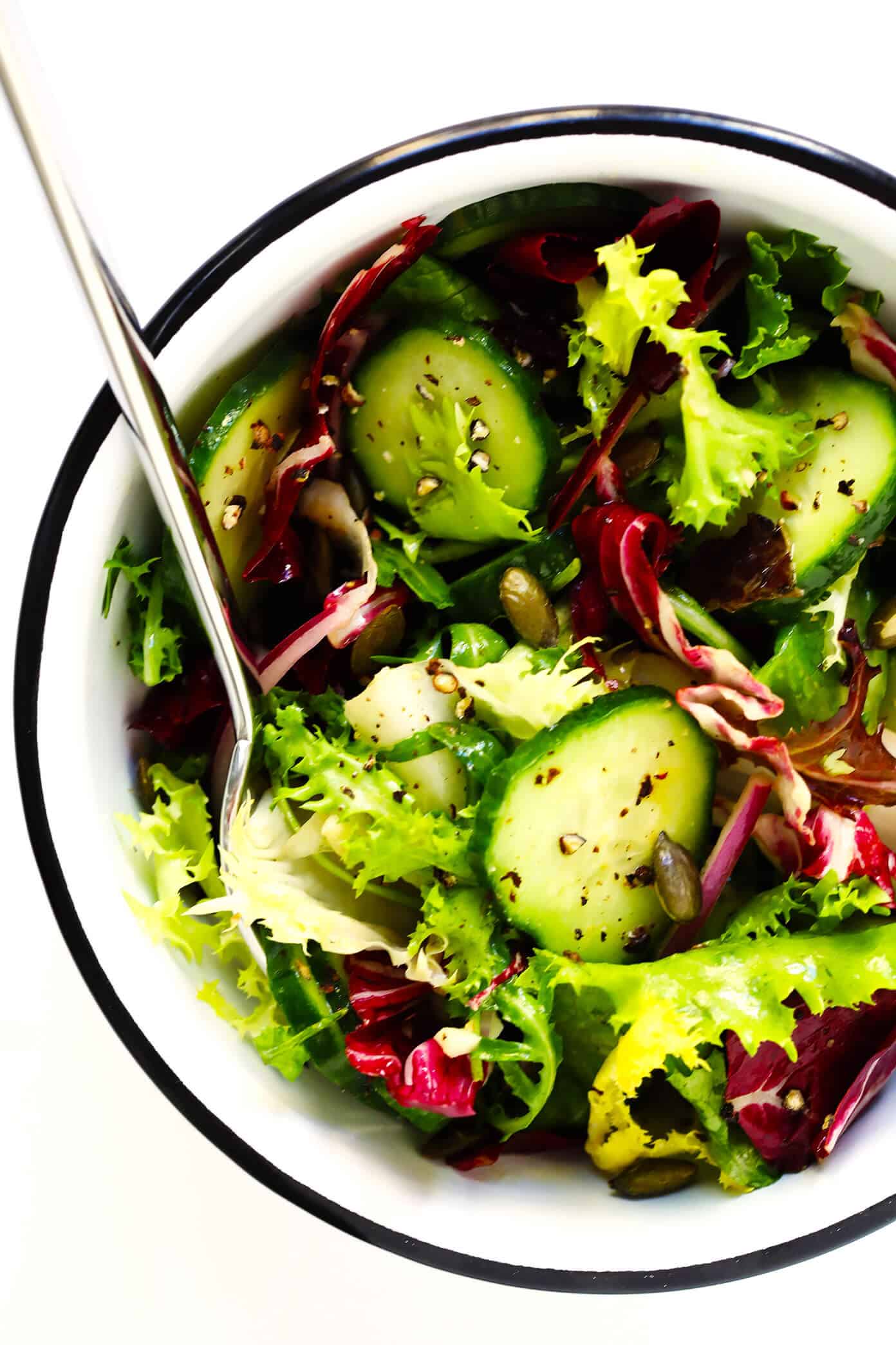 My favorite everyday salad recipe -- made with fresh greens, cucumber, red onion, pepitas (or your favorite nuts), and a simple lemon salad dressing. So easy, healthy and delicious! | gimmesomeoven.com #healthy #salad #recipe #dinner #vegetarian #vegan #glutenfree #easy #dressing #vinagirette Everyday Side Salad Recipe in Enamelware Bowl