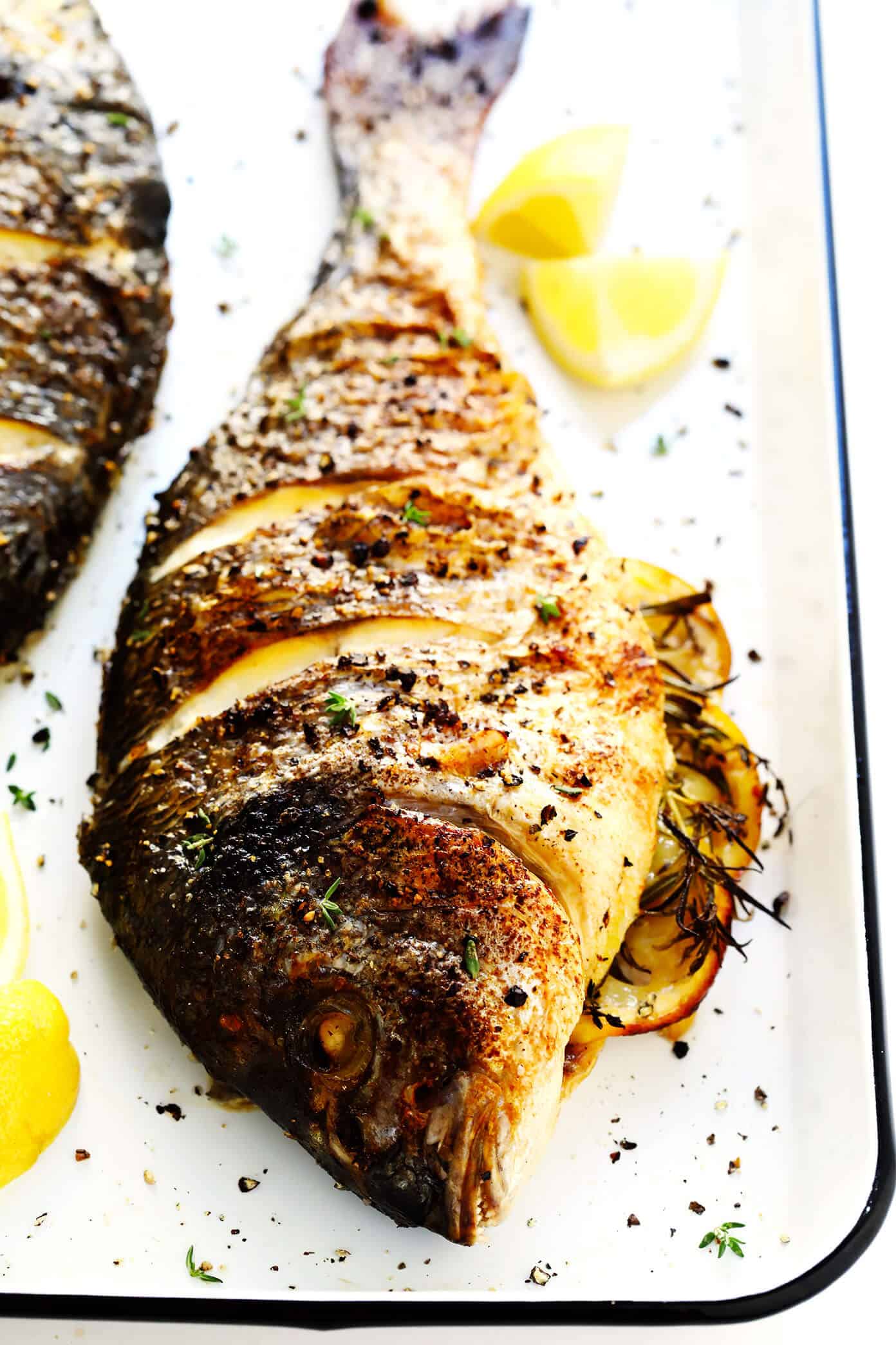 Learn how to cook a whole fish in the oven with this easy step-by-step tutorial and recipe! It's easy to make with mahi mahi, sea bass, branzino, red snapper, or whatever your favorite fish may be, and seasoned with a simple blend of lemon, garlic and herbs. The perfect healthy dinner! | Gimme Some Oven #fish #dinner #healthy #recipe #mahimahi #seabass The Best Oven Baked Fish Recipe