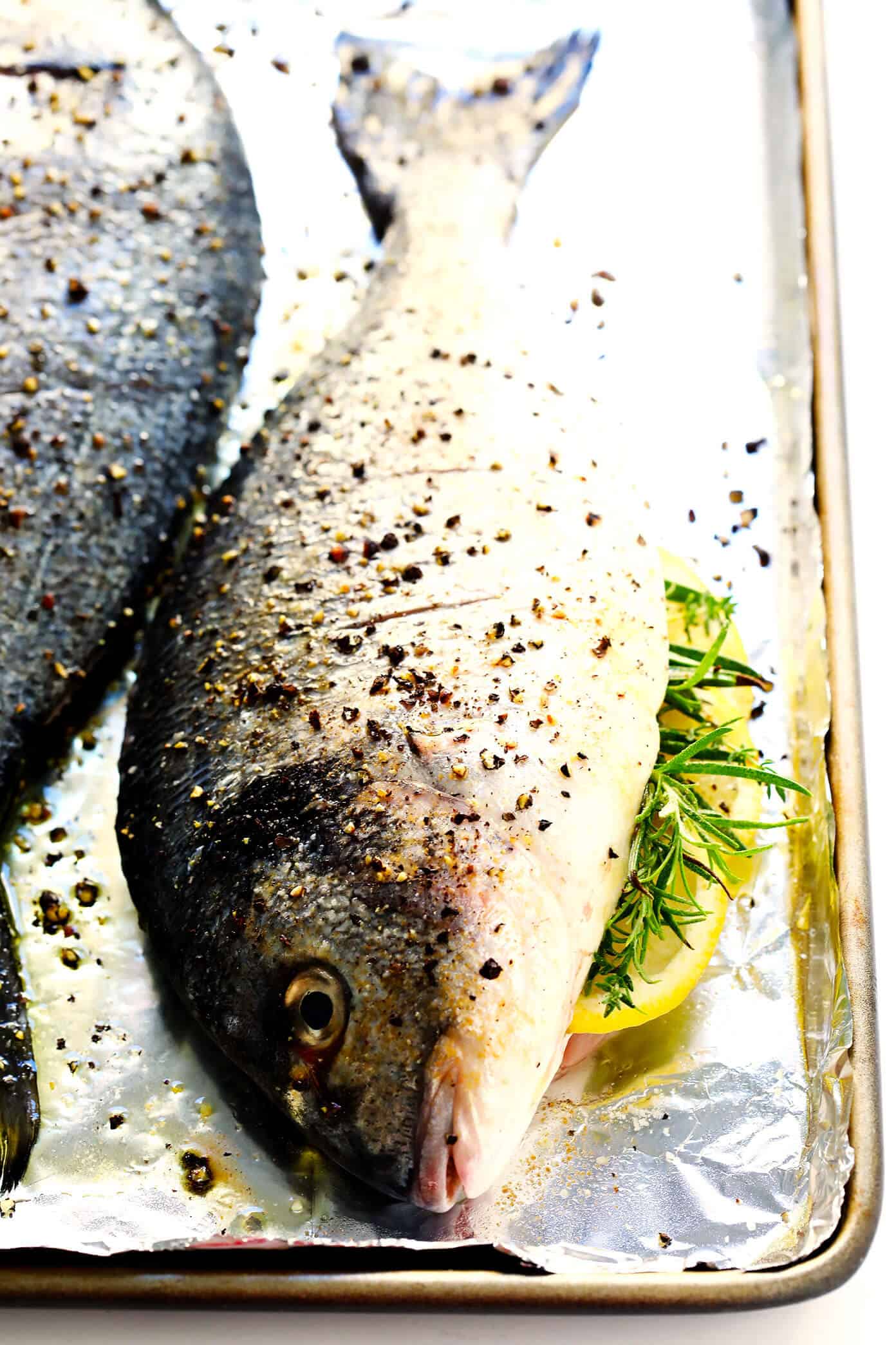 Learn how to cook a whole fish in the oven with this easy step-by-step tutorial and recipe! It's easy to make with mahi mahi, sea bass, branzino, red snapper, or whatever your favorite fish may be, and seasoned with a simple blend of lemon, garlic and herbs. The perfect healthy dinner! | Gimme Some Oven #fish #dinner #healthy #recipe #mahimahi #seabass How To Roast Fish