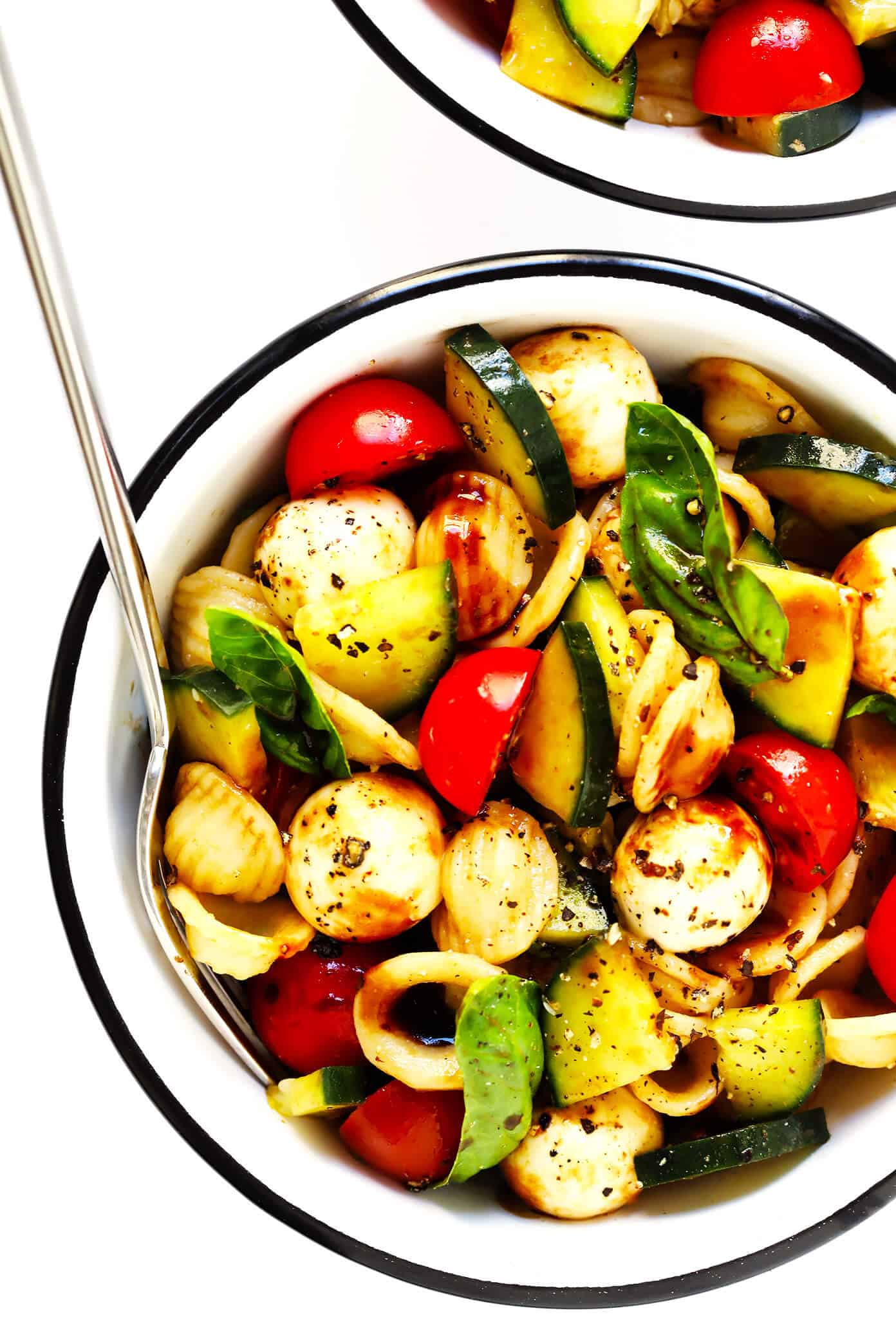 This Caprese Cucumber Salad recipe is quick and easy to make with 5 main ingredients -- fresh cucumber, tomato, basil, mozzarella and an easy balsamic glaze. Feel free to stir in some pasta if you'd like, too, to make a pasta salad! | Gimme Some Oven #caprese #cucumber #salad #pastasalad #summer #dinner #recipe Cucumber Caprese Pasta Salad Recipe