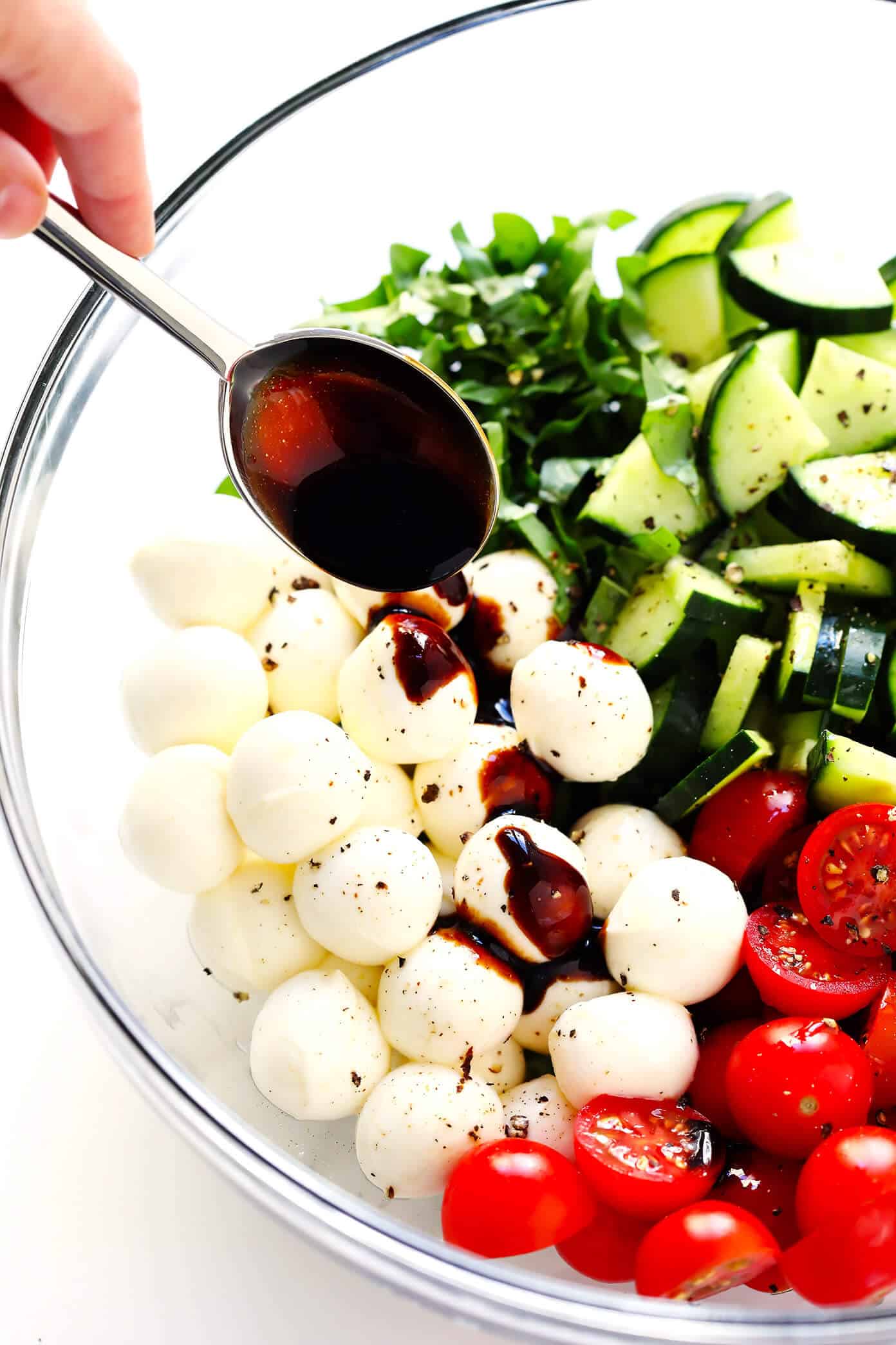 This Caprese Cucumber Salad recipe is quick and easy to make with 5 main ingredients -- fresh cucumber, tomato, basil, mozzarella and an easy balsamic glaze. Feel free to stir in some pasta if you'd like, too, to make a pasta salad! | Gimme Some Oven #caprese #cucumber #salad #pastasalad #summer #dinner #recipe How To Make A Caprese Salad With Cucumber