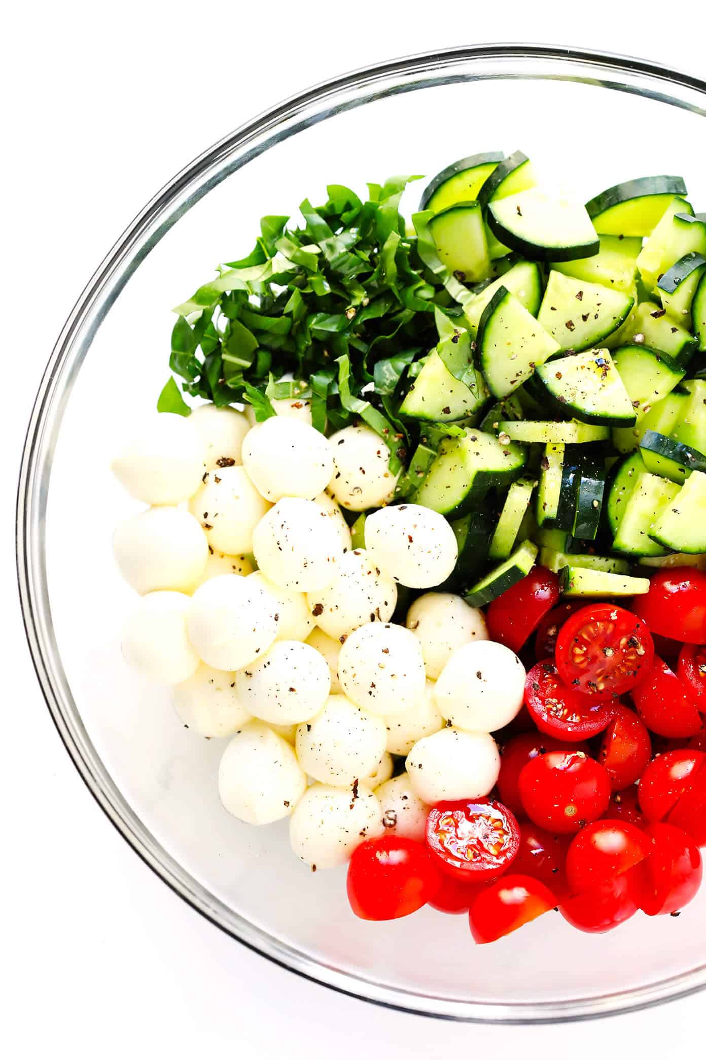 This Caprese Cucumber Salad recipe is quick and easy to make with 5 main ingredients -- fresh cucumber, tomato, basil, mozzarella and an easy balsamic glaze. Feel free to stir in some pasta if you'd like, too, to make a pasta salad! | Gimme Some Oven #caprese #cucumber #salad #pastasalad #summer #dinner #recipe Caprese Cucumber Salad Ingredients