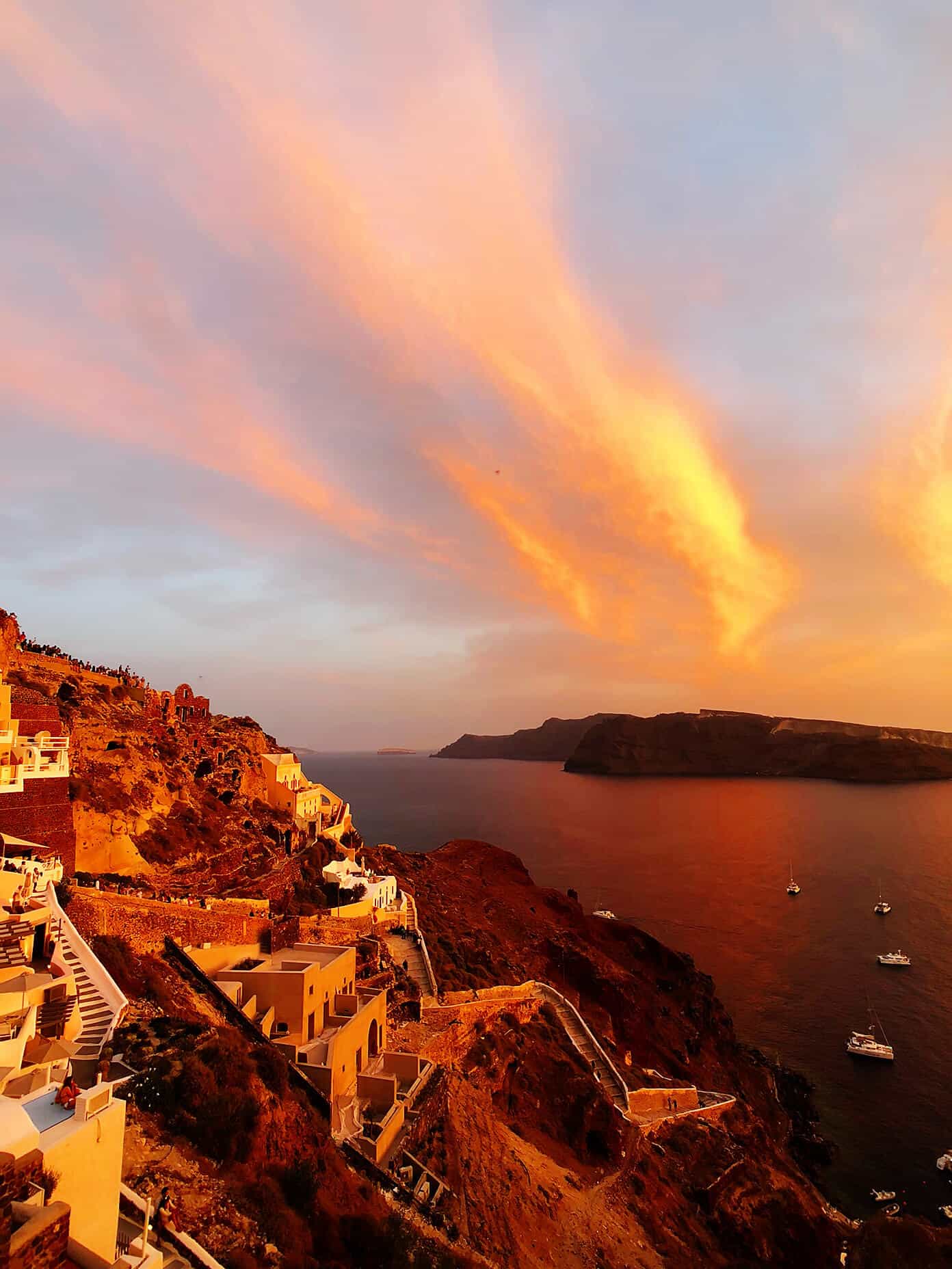 The Gimme Some Oven travel guide for restaurants to eat, hotels to stay and places to visit in Santorini, Greece. | Gimme Some Oven #santorini #greece #travel #traveltips #europe #vacation #islands #hotel #restaurant Fiery Sunset Views in Oia Santorini Greece