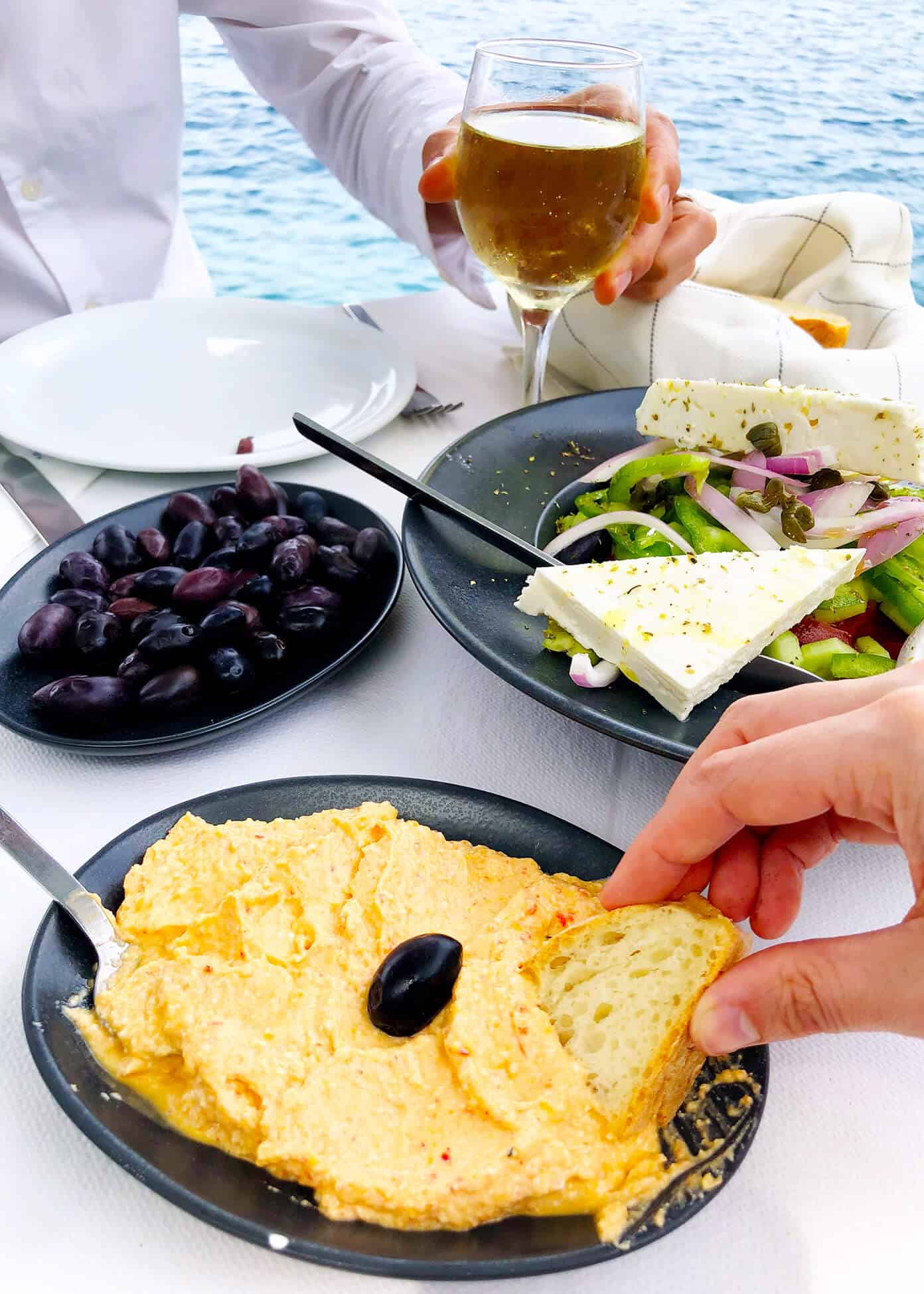 The Gimme Some Oven travel guide for restaurants to eat, hotels to stay and places to visit in Santorini, Greece. | Gimme Some Oven #santorini #greece #travel #traveltips #europe #vacation #islands #hotel #restaurant Spicy Cheese Dip, Olives and Greek Salad for Lunch at Sunset Taverna in Santorini, Greece